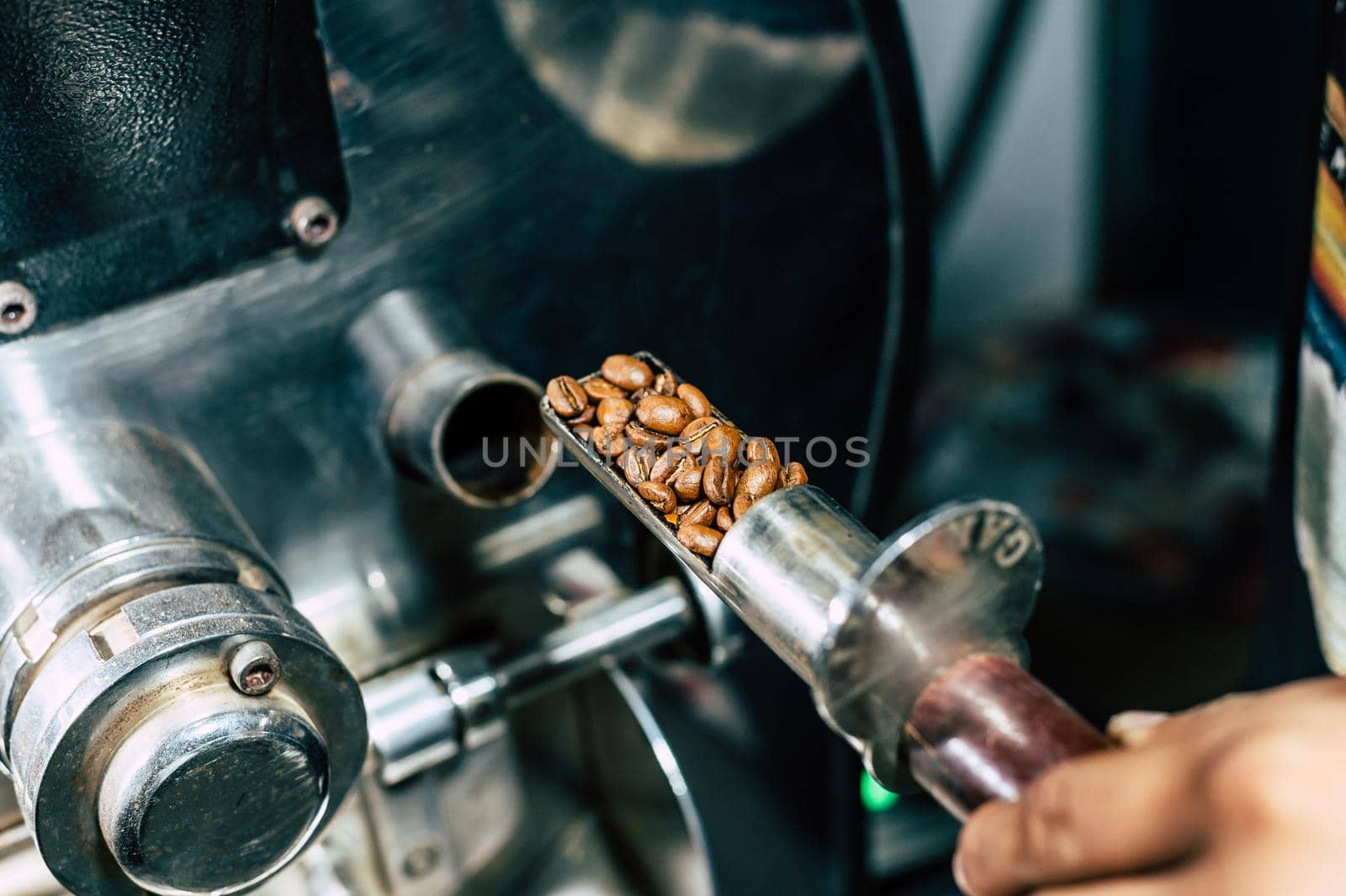 Coffee roaster machine at coffee roasting process. Mixing coffee beans