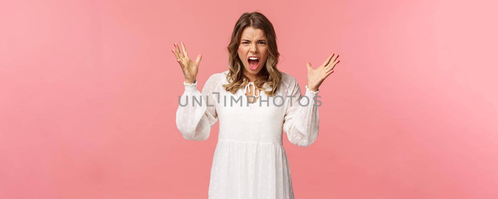 Portrait of tensed young angry blond girlfriend yelling, shouting and freaking-out over huge mess, raise hands up dismay grimacing aggressive, frowning and shouting during argument.