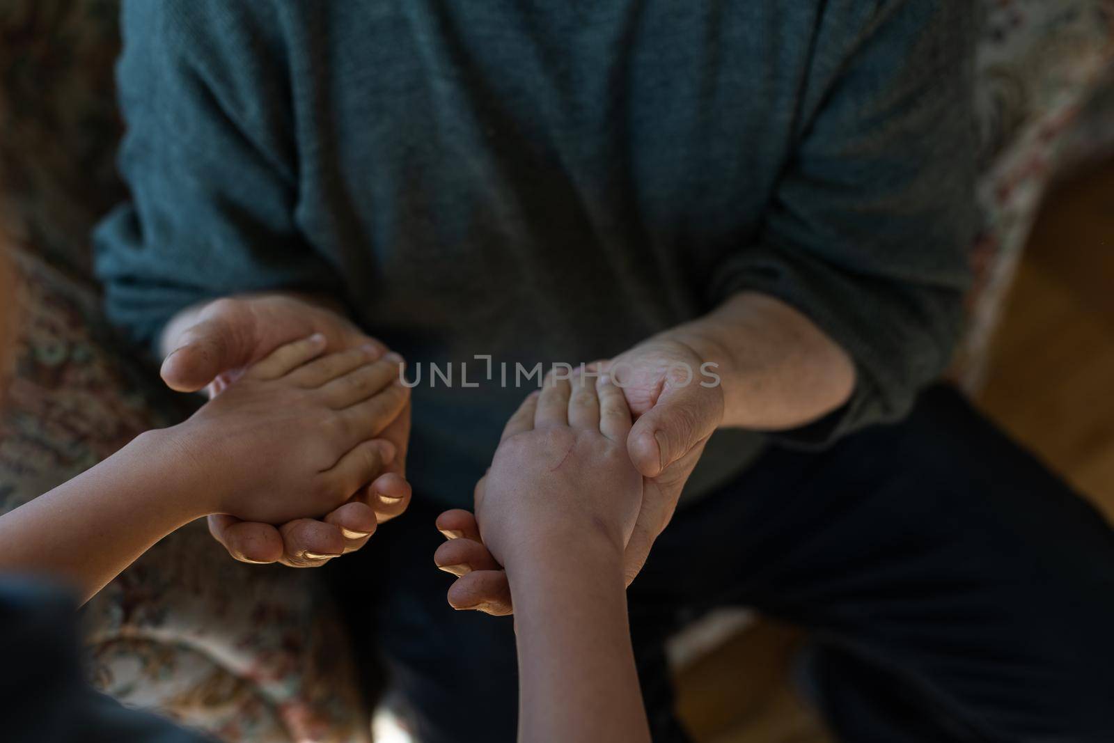 the hands of the child embracing a hand of the old man by Andelov13