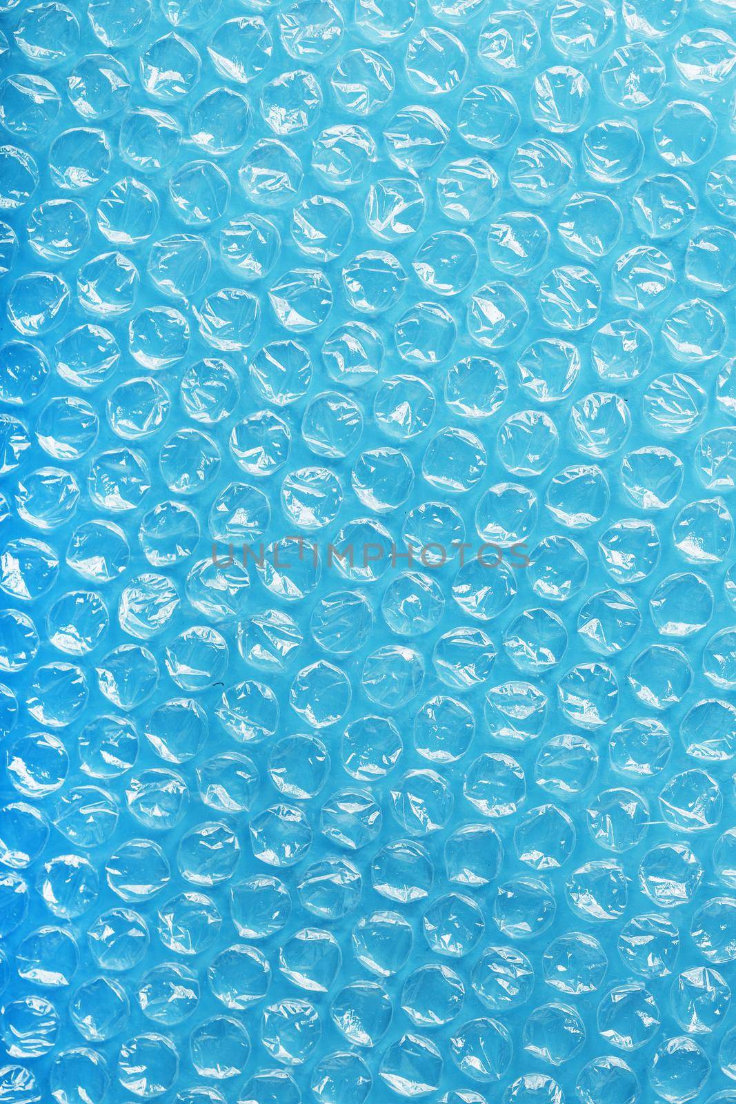 Packing bubble wrap for parcels on a blue background in full screen by AlexGrec