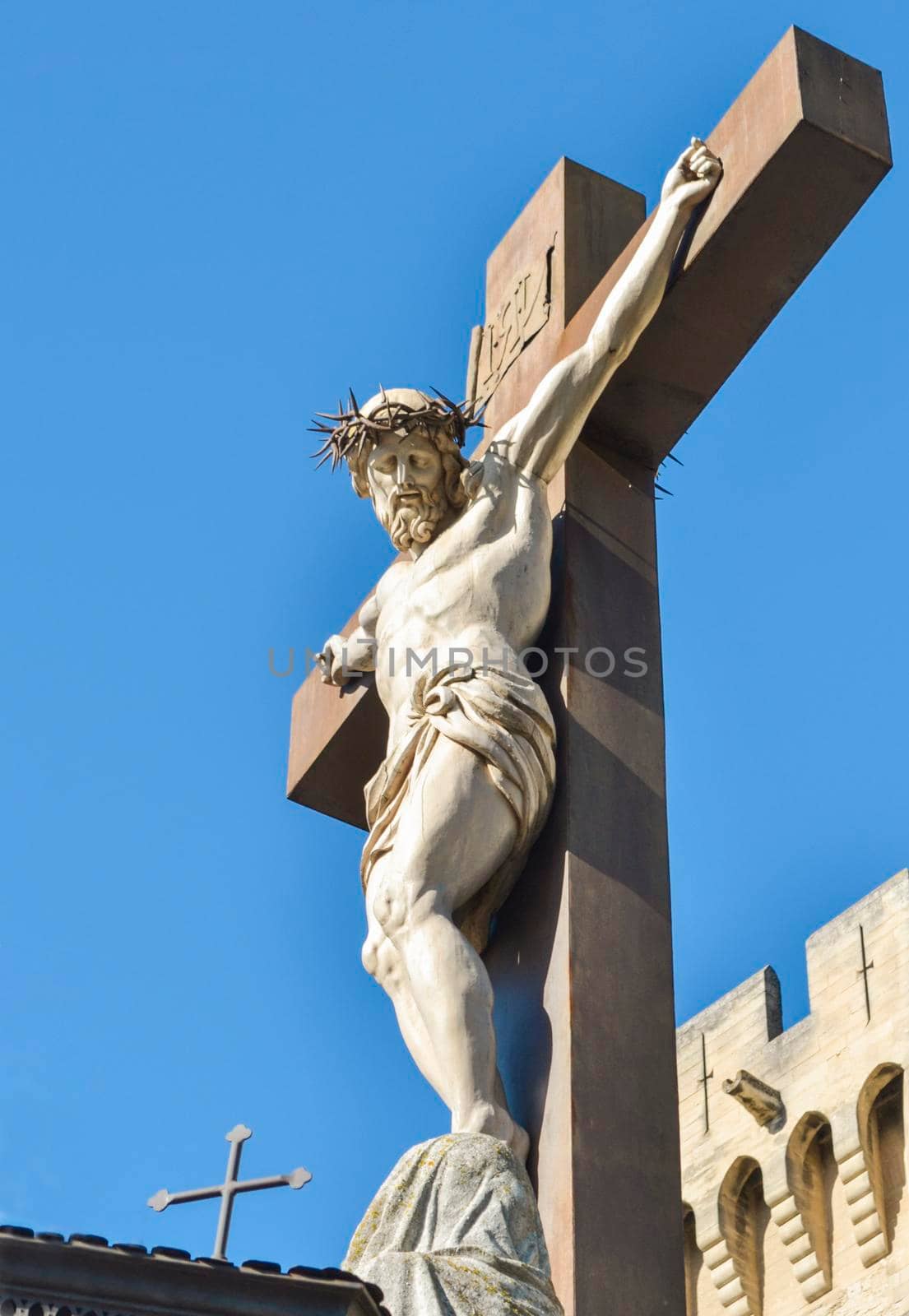 A statue of Jesus hanging from a cross with crown of thorns