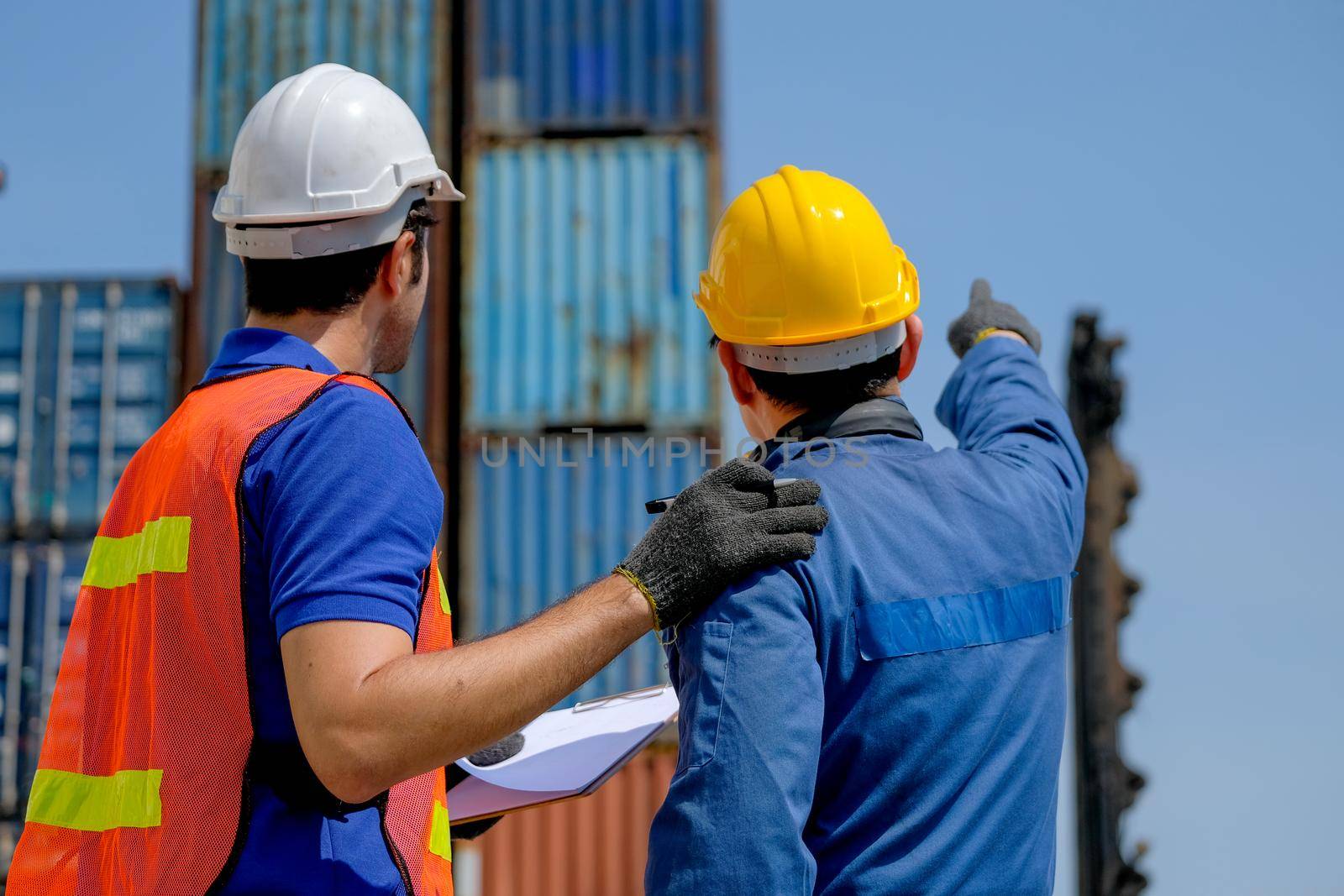 The back of engineer and technician help together for checking the quality of product and system in cargo containers area.