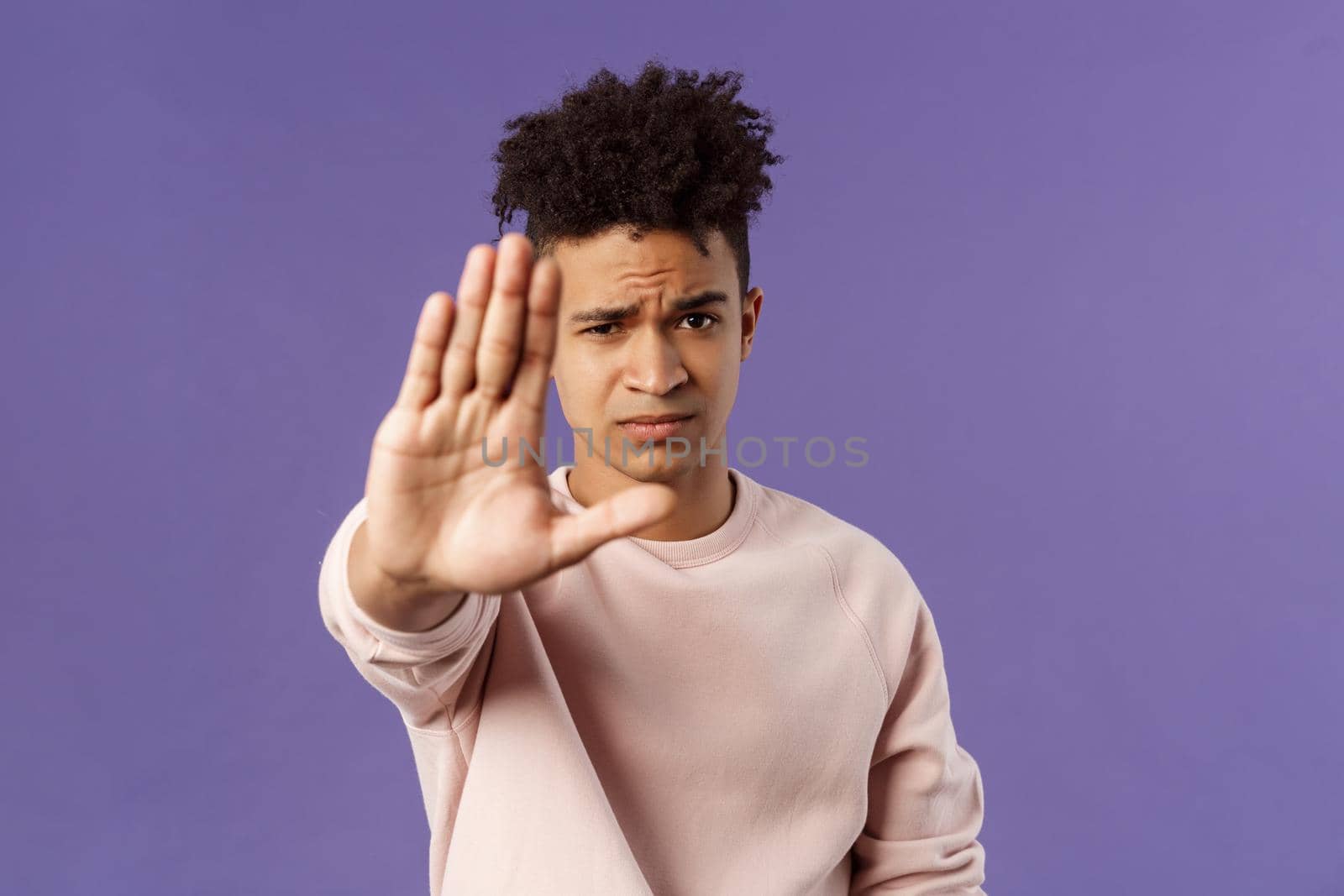 Man you should stop. Close-up portrait of young serious-looking male friend trying to warn person of doing something bad, raise hand to prohibit, forbid no trespassing, purple background by Benzoix