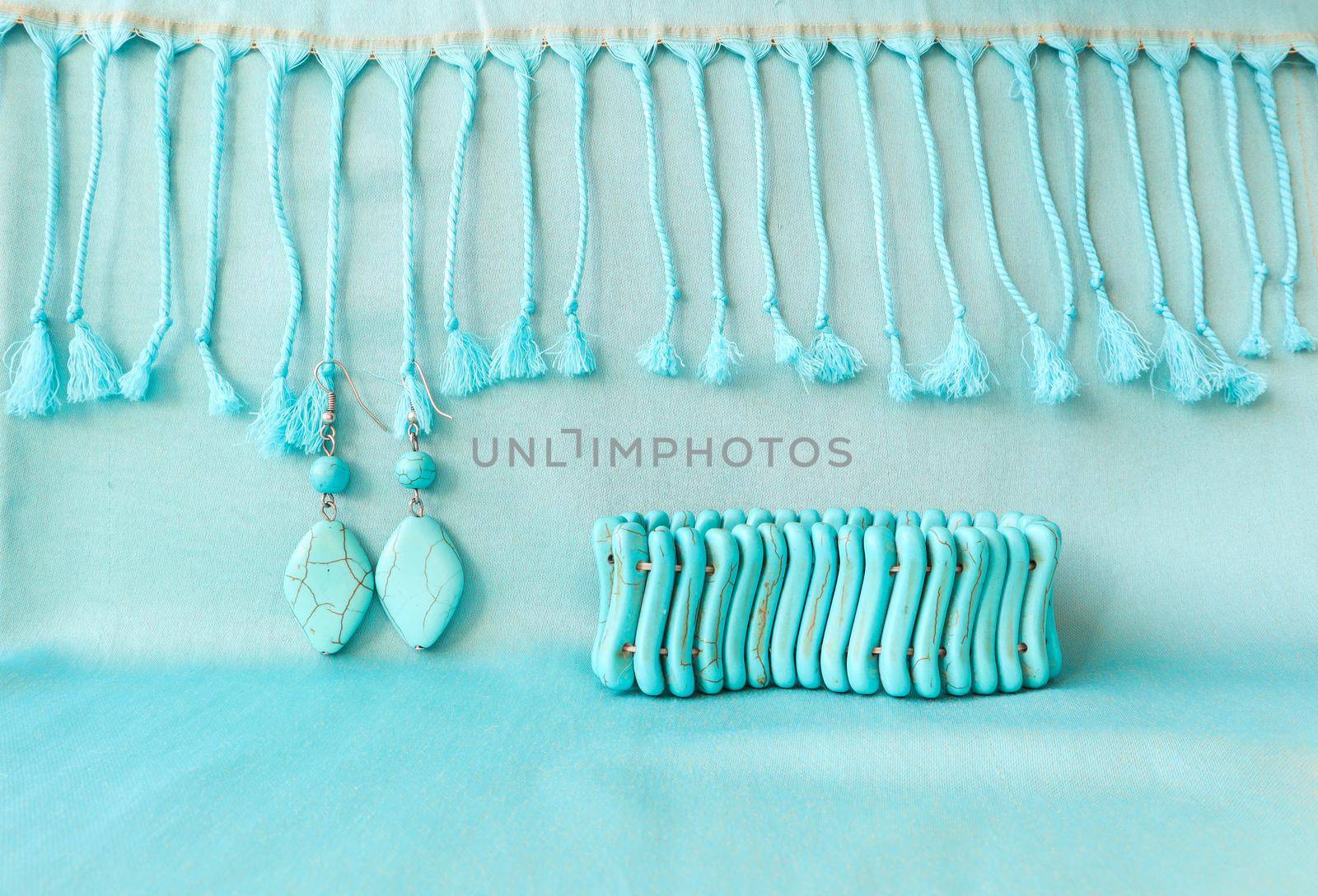 Turquoise bracelet and earrings from natural stone on fringed scarf