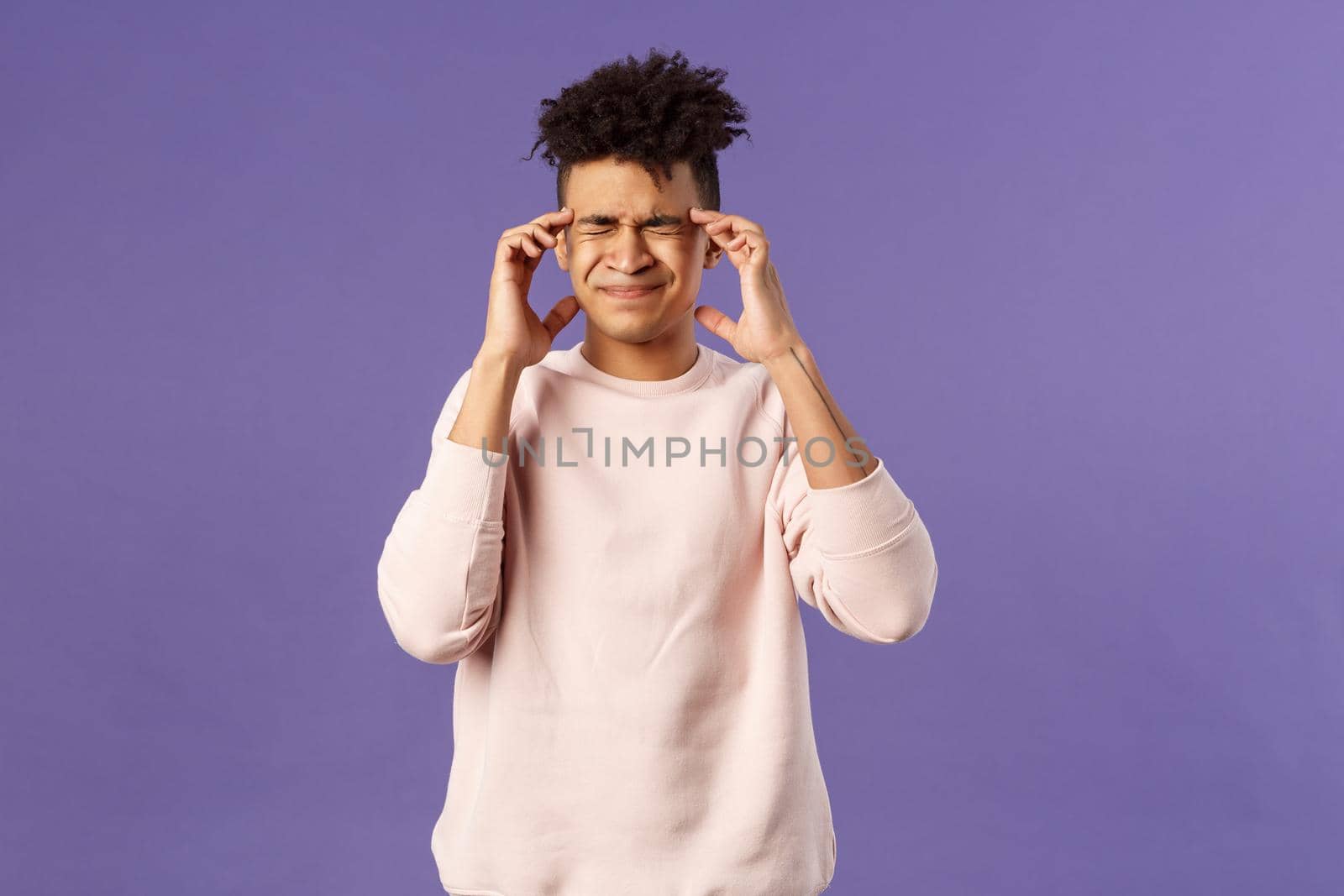 Portrait of intense, pressed young male student overworked, feel tired and dizzy, grimacing from painful feeling in head, having headache or migraine, touching temples, cant stand pain by Benzoix