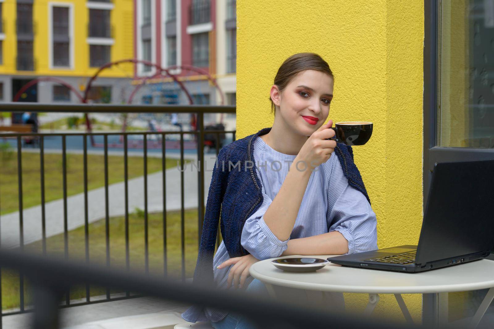 Charming happy woman student using laptop computer to prepare for the course work. Concept of working outdoors