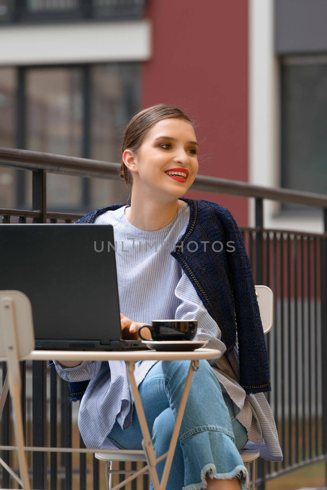 Charming happy woman student sitting in a cafe and using laptop computer to prepare for the course work. by Ashtray25