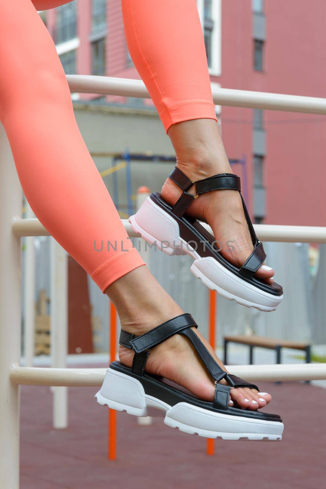 Sexy woman's sunburnt legs wearing black sandals and peach leggings, outdoors by Ashtray25