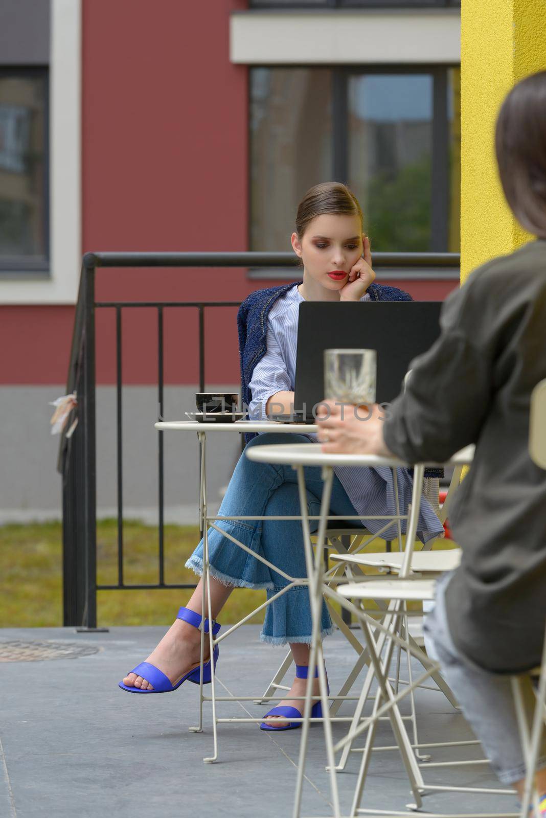 Charming happy woman student using laptop computer to prepare for the course work. Concept of working outdoors