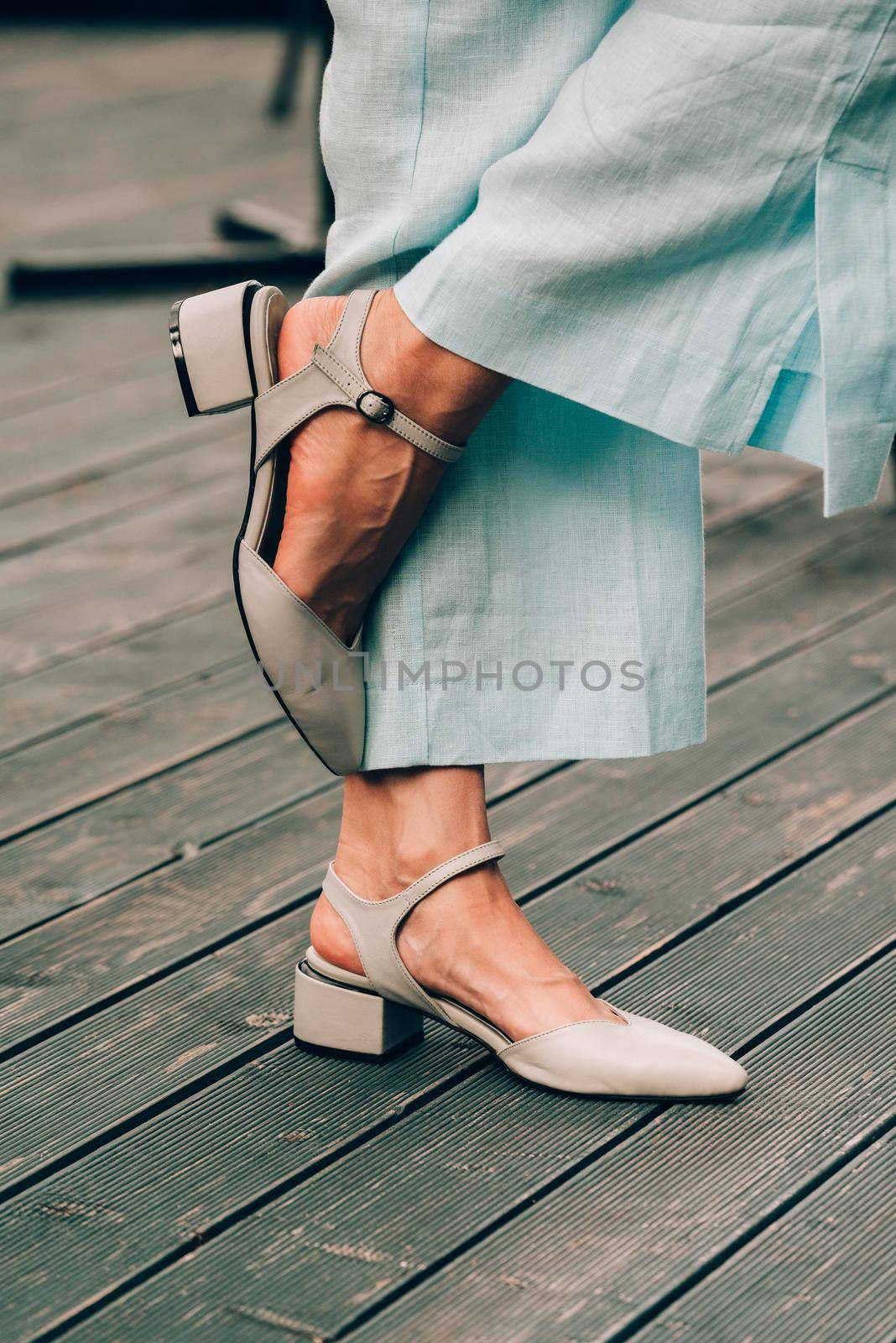 female legs in blue cotton pants and beige shoes. Summer fashion