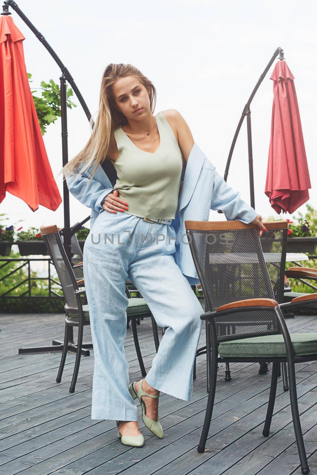 Sexy stylish woman with a blond hair wear blue cotton suit posing on the street. summer collection style fashion.