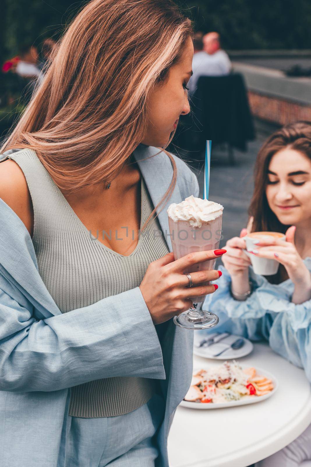 A woman's hand holds a refreshing cocktail in a glass with a tube. by Ashtray25