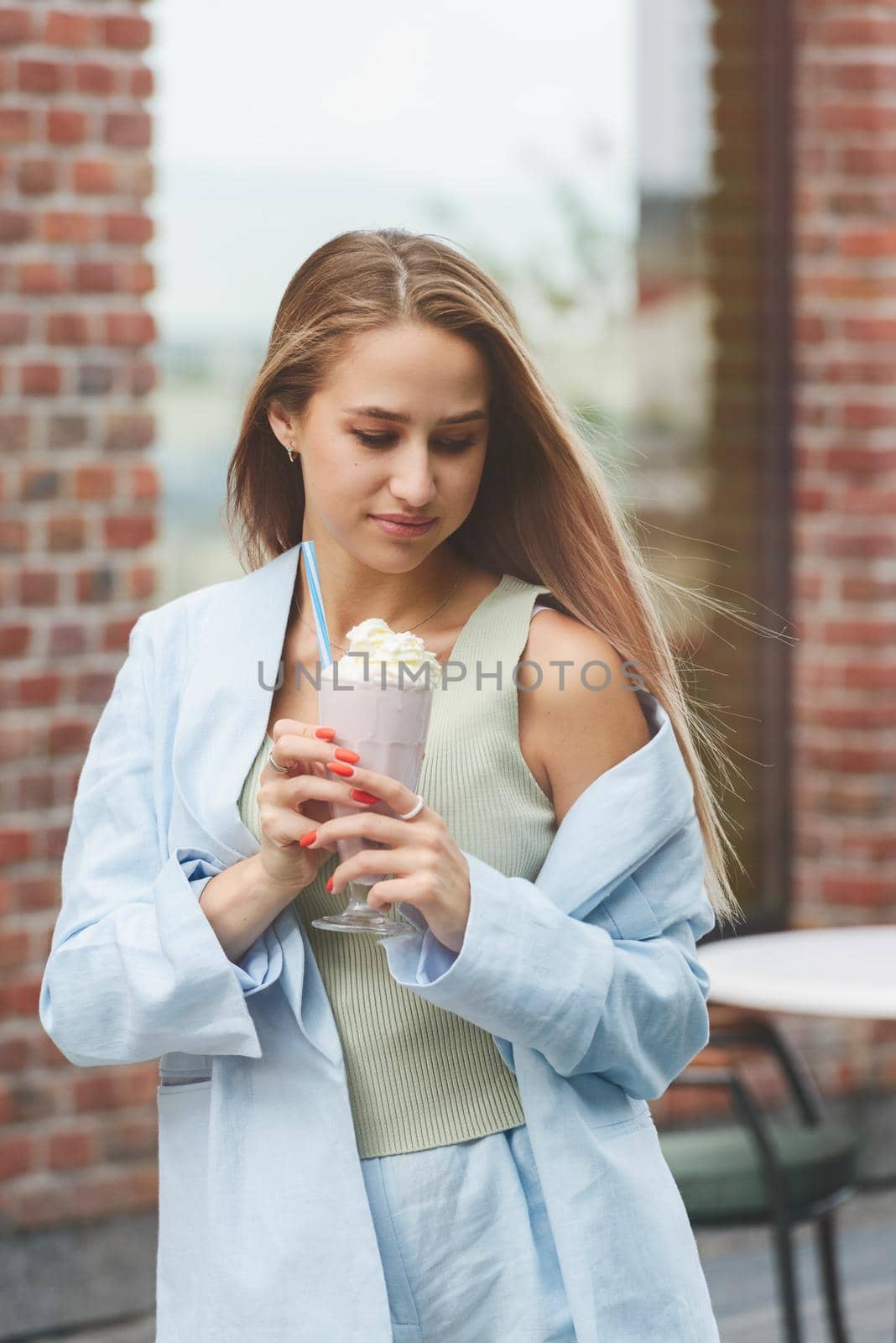 A woman's hand holds a refreshing cocktail in a glass with a tube. by Ashtray25