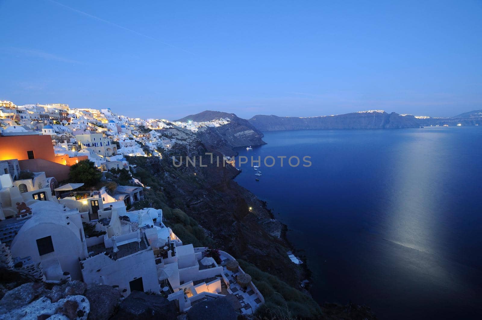 Sunset night view of traditional Greek village Oia on Santorini island in Greece. Santorini is iconic travel destination in Greece, famous of its sunsets and traditional white architecture