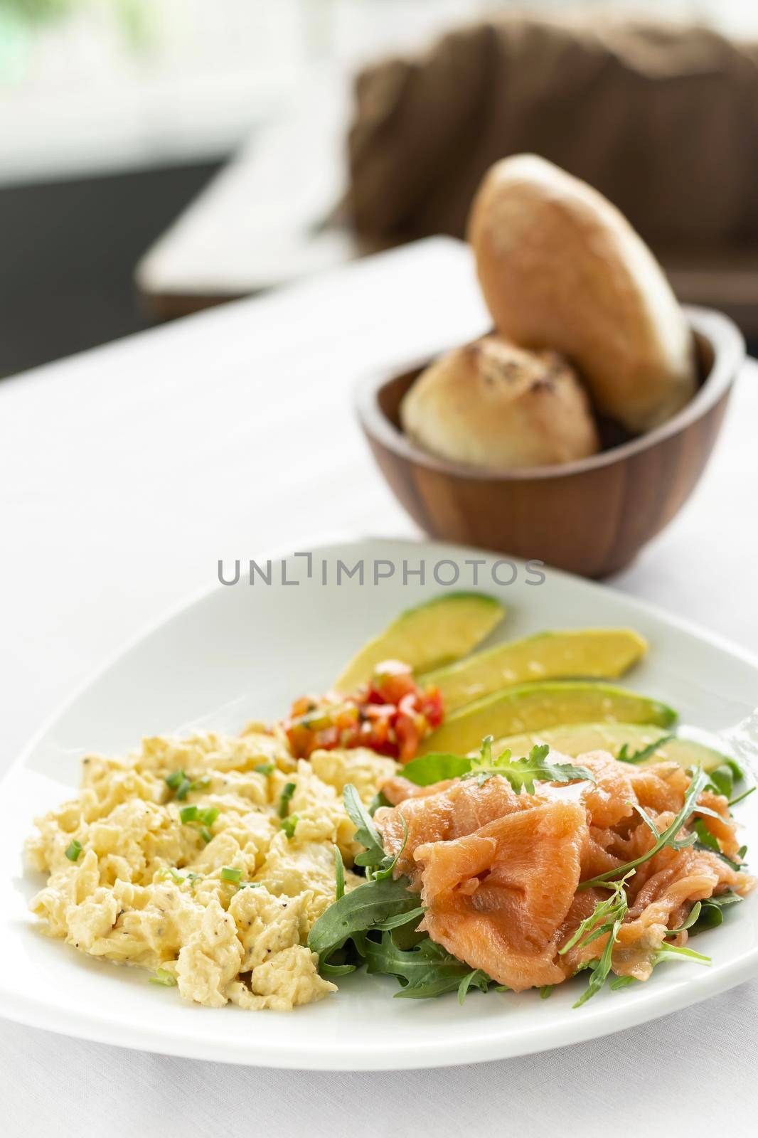 scrambled eggs with smoked salmon and avocado healthy breakfast on restaurant table