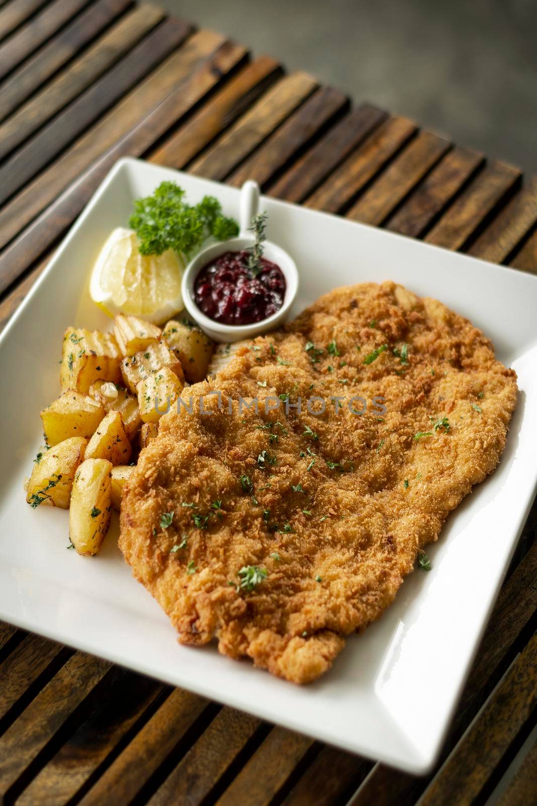 german veal schnitzel cutlet with potato and red berry sauce in berlin restaurant