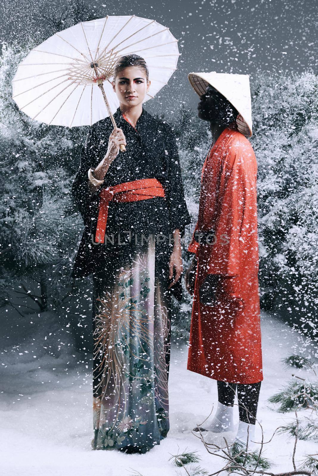 Fashion fairytale. Fashion shot of a man and woman wearing oriental-style clothing in a snowy forest. by YuriArcurs