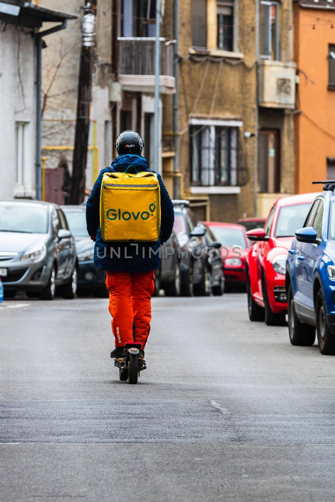 A Glovo food delivery courier on a bike  in Bucharest, Romania, 2022 by vladispas