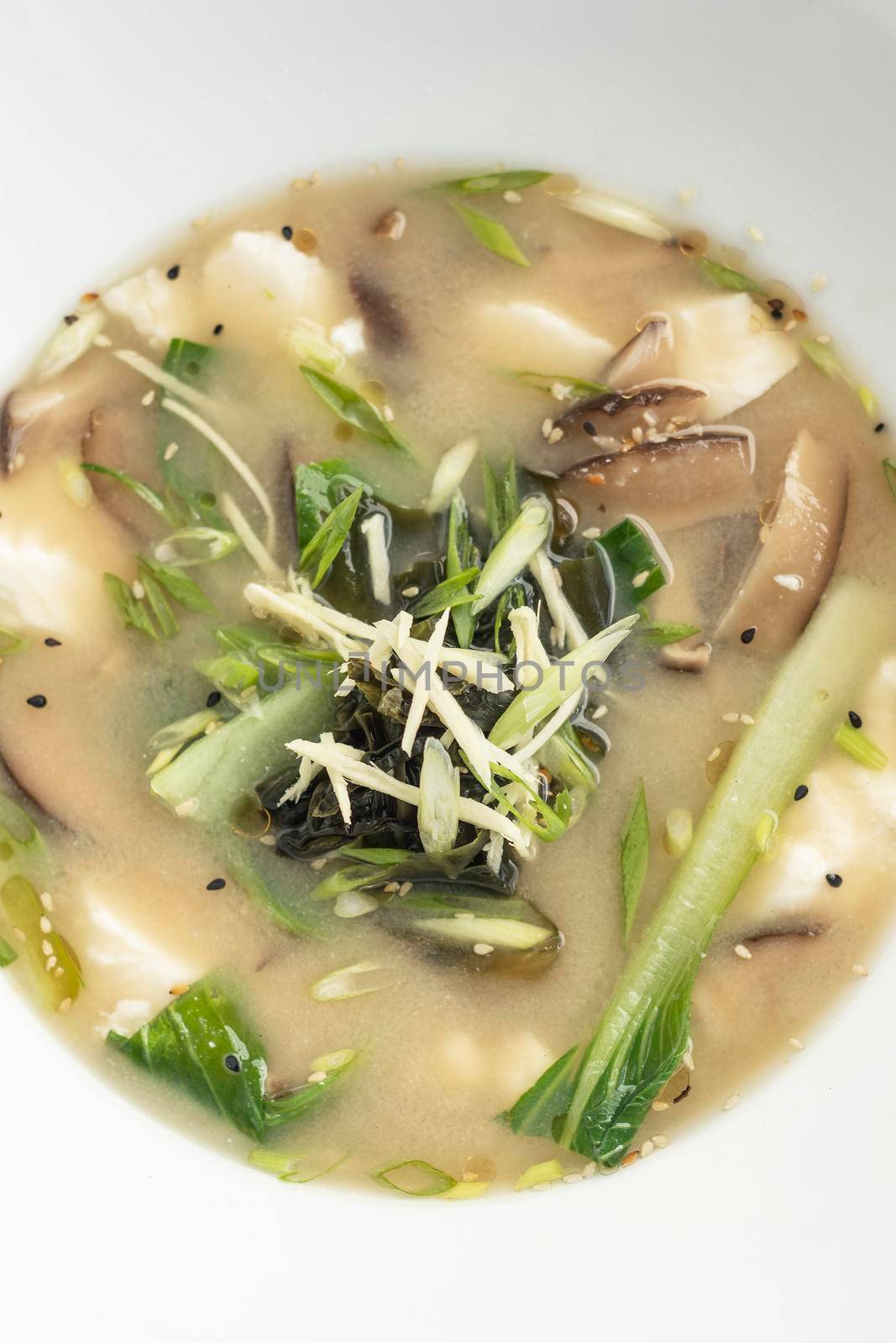 traditional japanese miso soup with tofu and mixed vegetables on white background