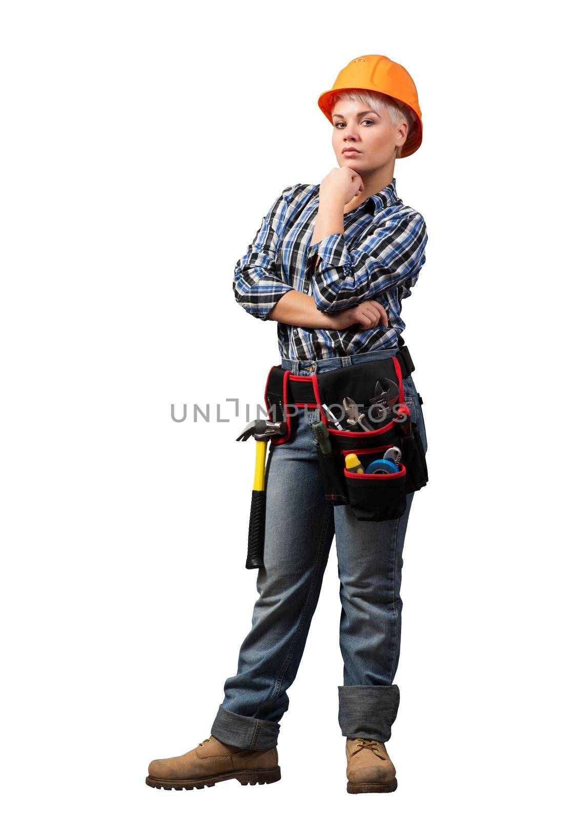 Concentrated female construction worker in hardhat standing with folded arms. Pensive young technician in checkered blue shirt isolated on white background. Industrial manufacturing and construction