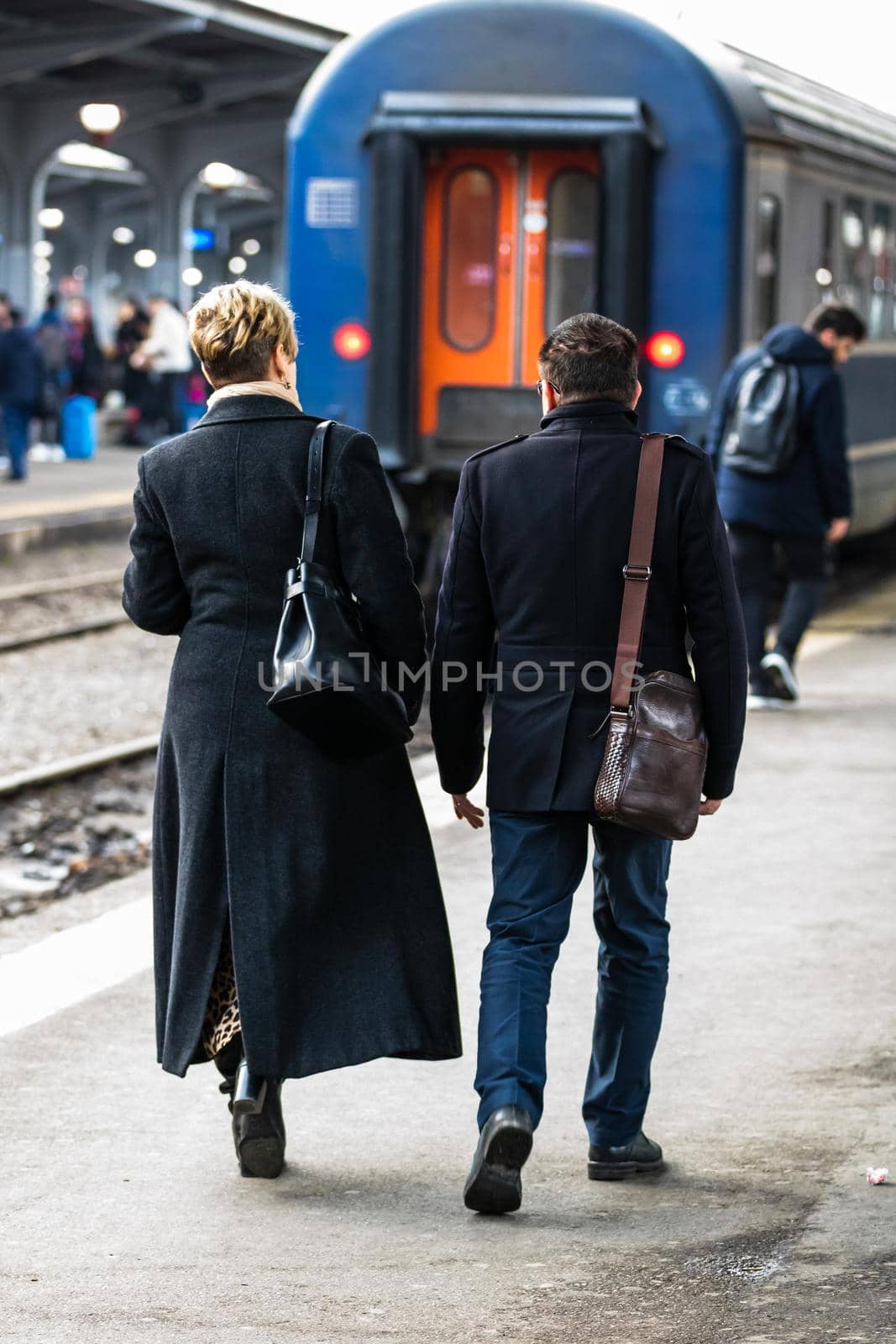 Travelers and commuters waiting for a train on the train platform of Bucharest North Railway Station (Gara de Nord Bucharest) in Bucharest, Romania, 2022 by vladispas