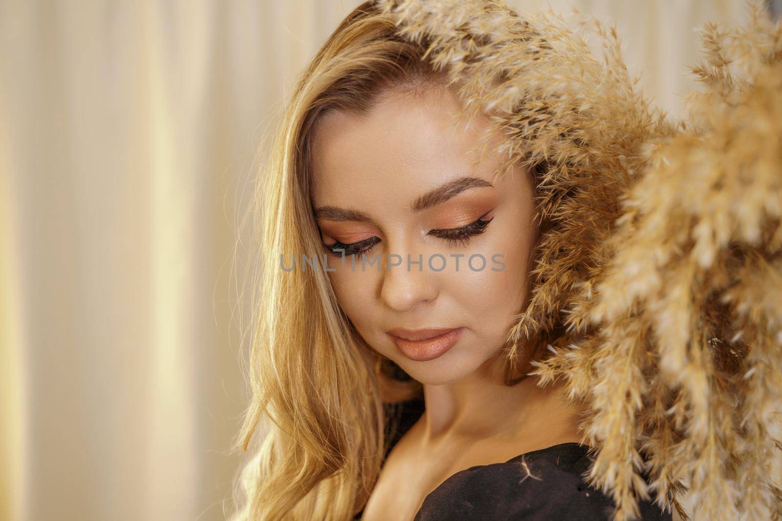 Beautiful young blonde woman face closeup portrait in studio on a light background by Matiunina