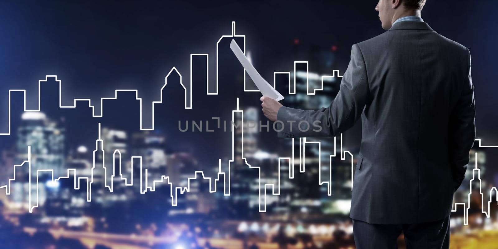 Rear view of businessman against modern cityscape holding papers in hand