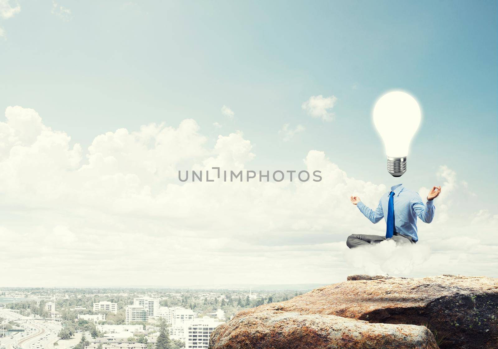 Businessman sitting in lotus pose and light bulb instead of his head