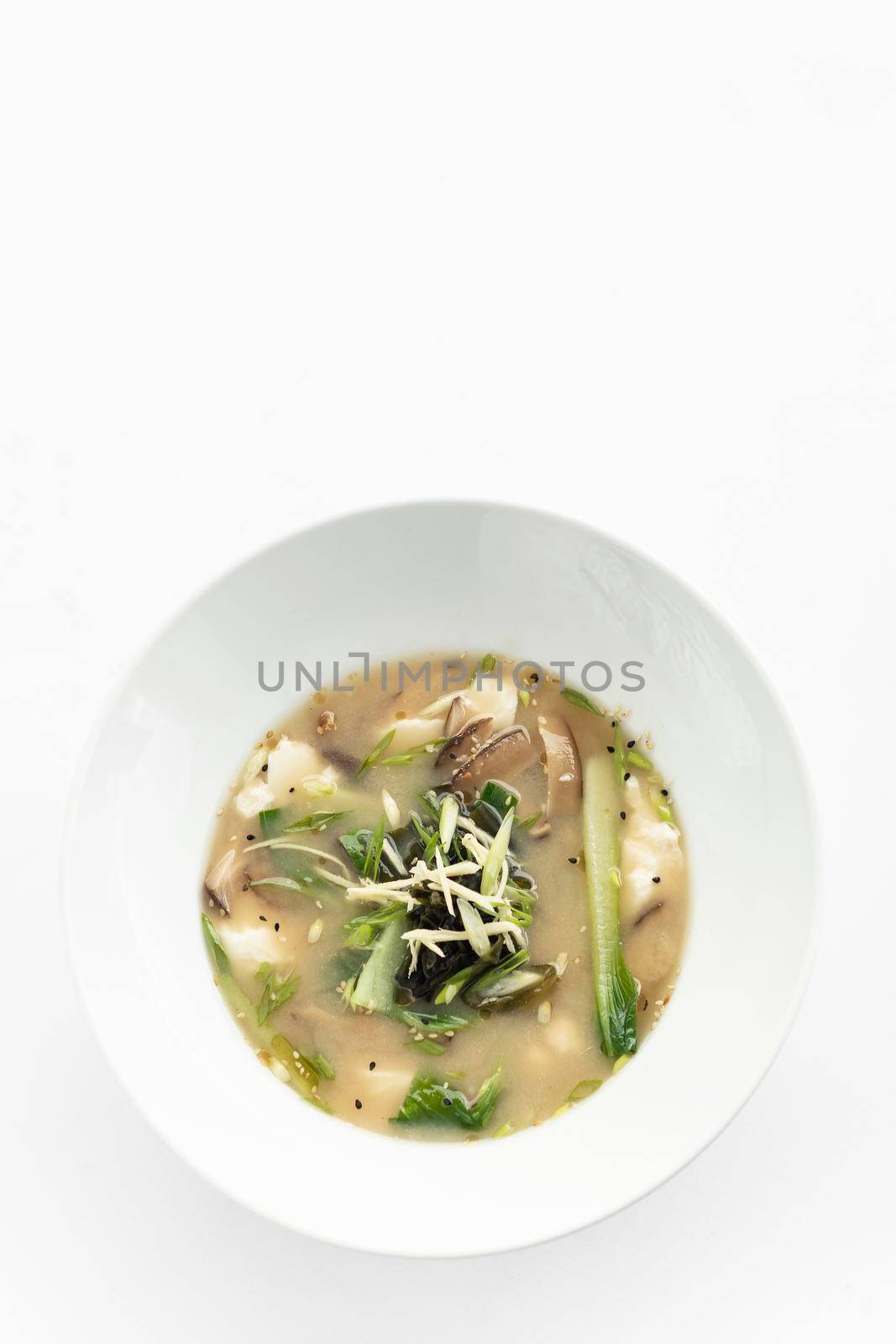 traditional japanese miso soup with tofu and mixed vegetables on white background