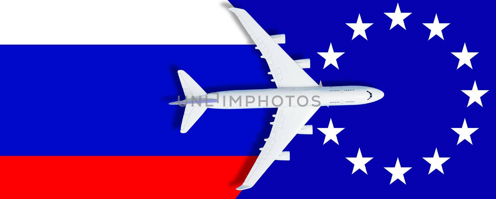 Russian flag, toy plane and barbed wire on blue background, concept of banning aircraft departing from Russia