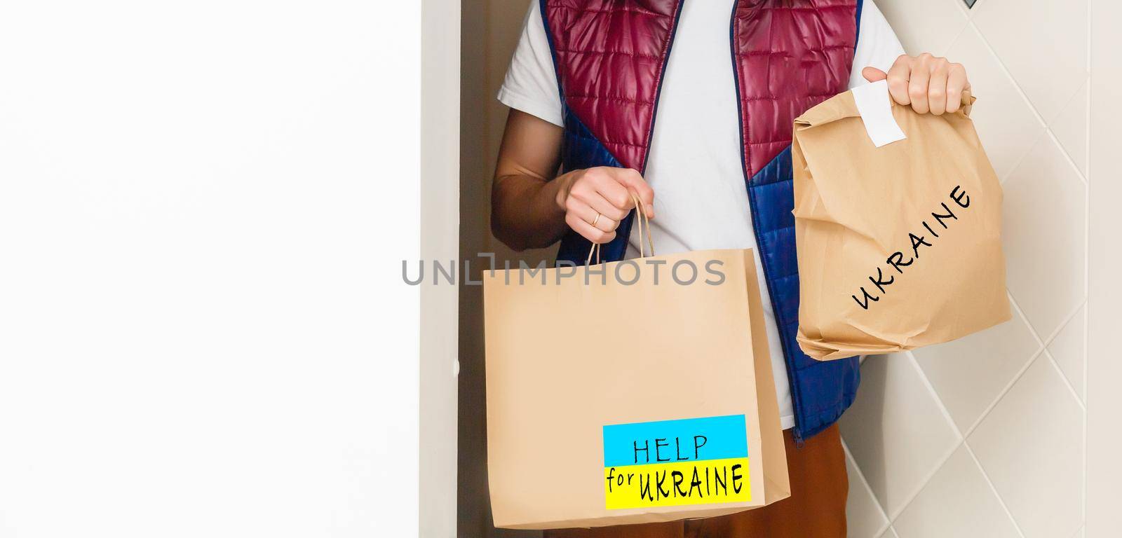 A man holds a box of aid for Ukrainian refugees and poor citizens who find themselves in a war between Ukraine and Russia. Humanitarian aid concept. Donate for refugees