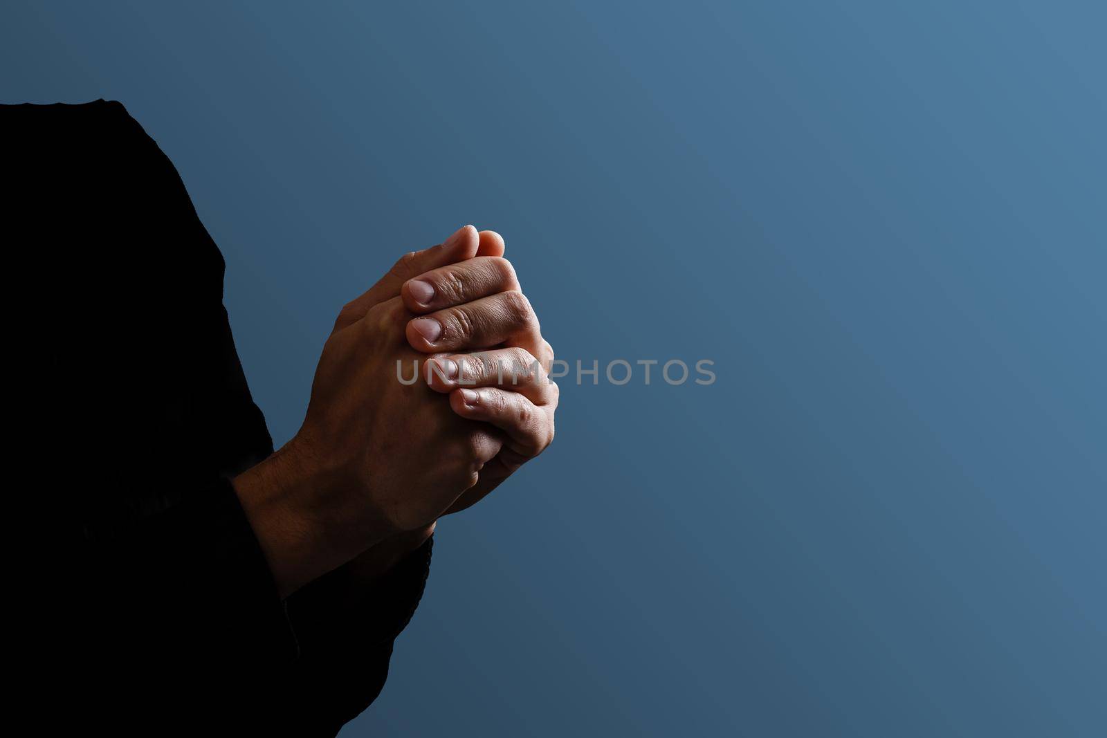 Praying hands with faith in religion and belief in God on dark background. Power of hope or love and devotion. Namaste or Namaskar hands gesture. Prayer position by Andelov13