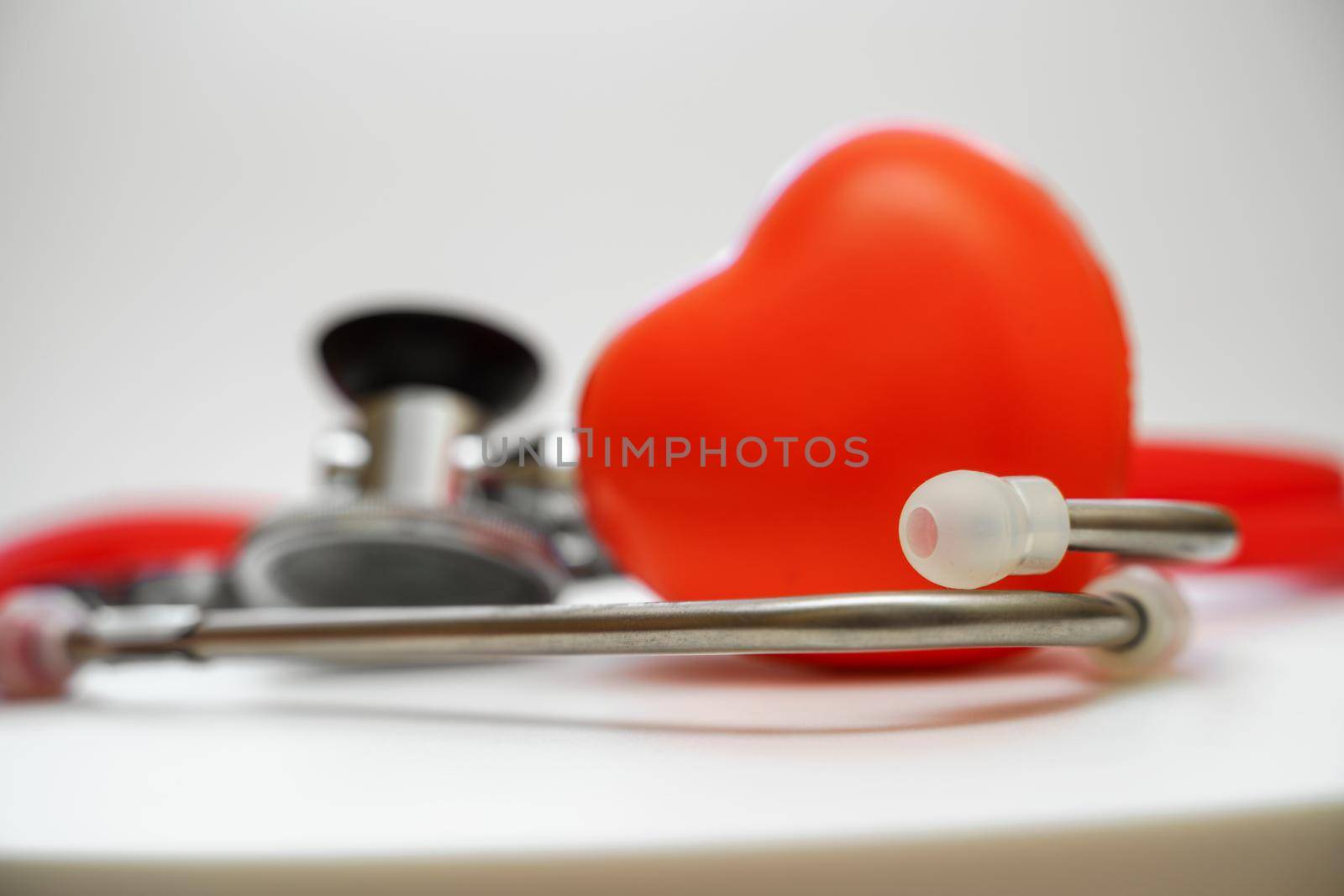 Stethoscope and red heart on white background, heart health, health insurance concept.