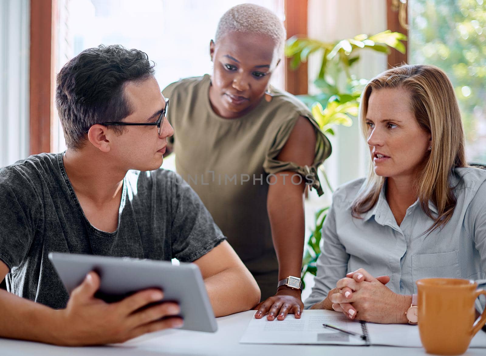 Shot of a group of businesspeople working together on a digital tablet in an office.