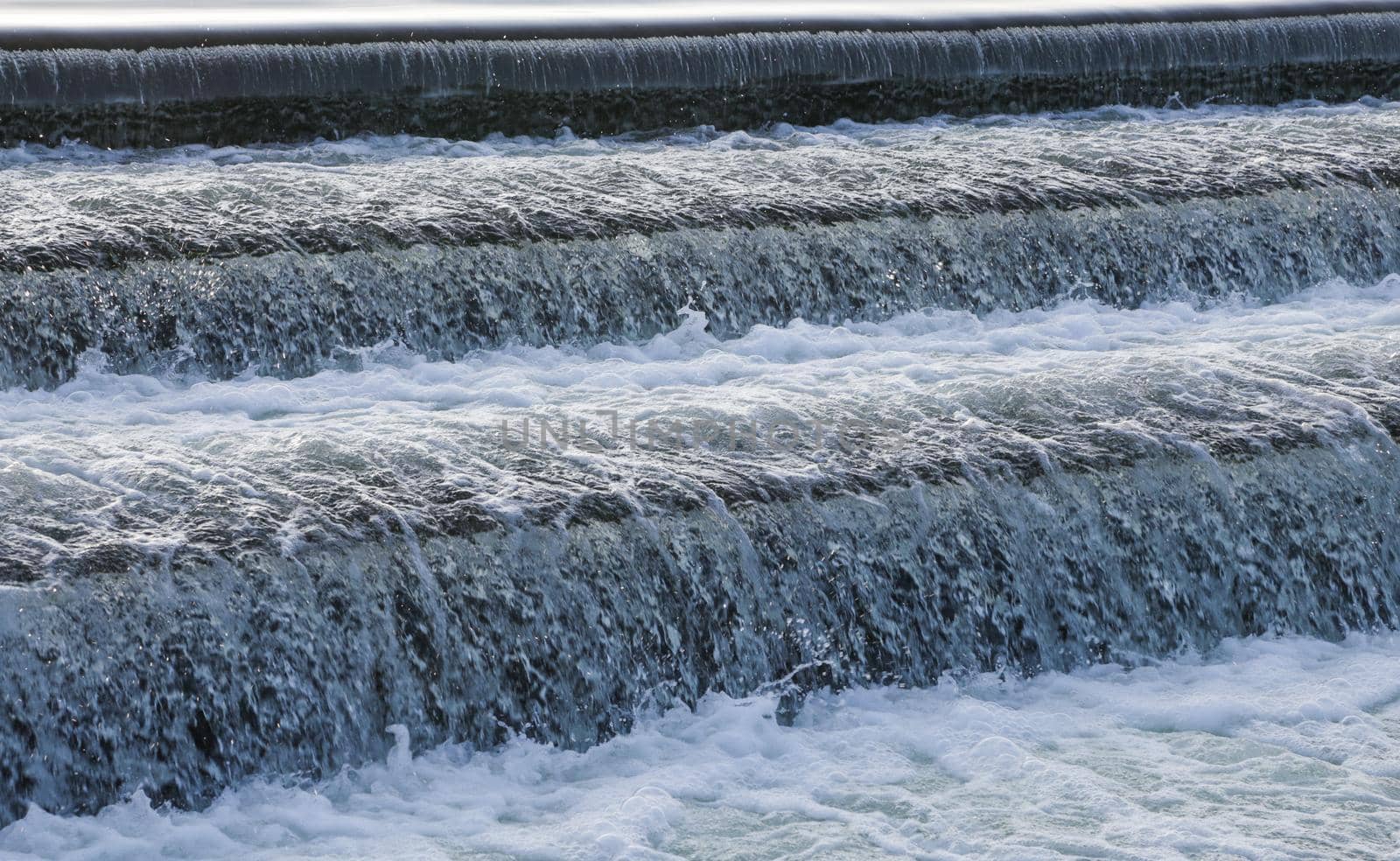 A close-up of a waterfall descending from a lake.