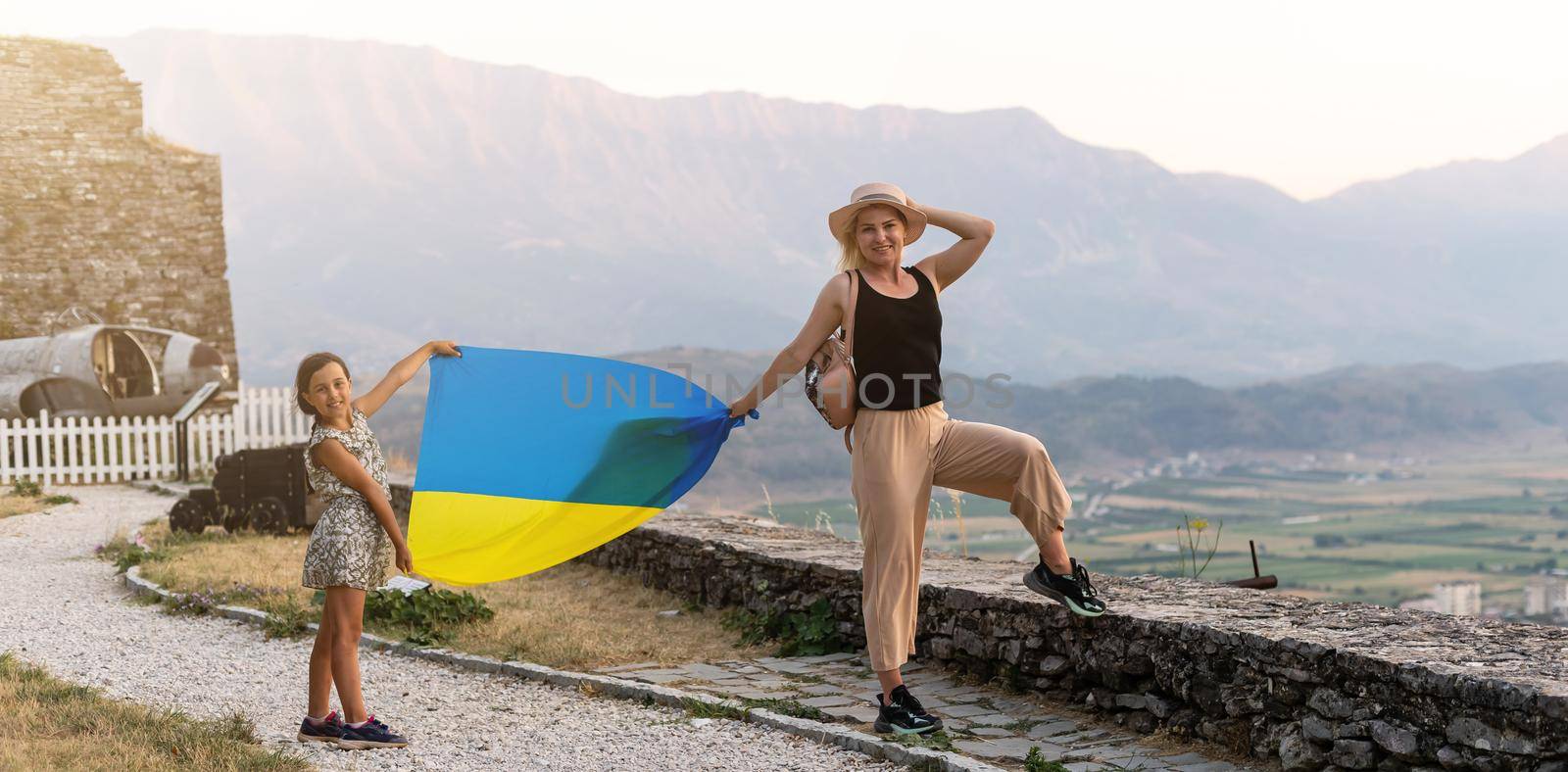 Family of hikers in Ukrainian with Ukrainian flag staying in the mountains. by Andelov13
