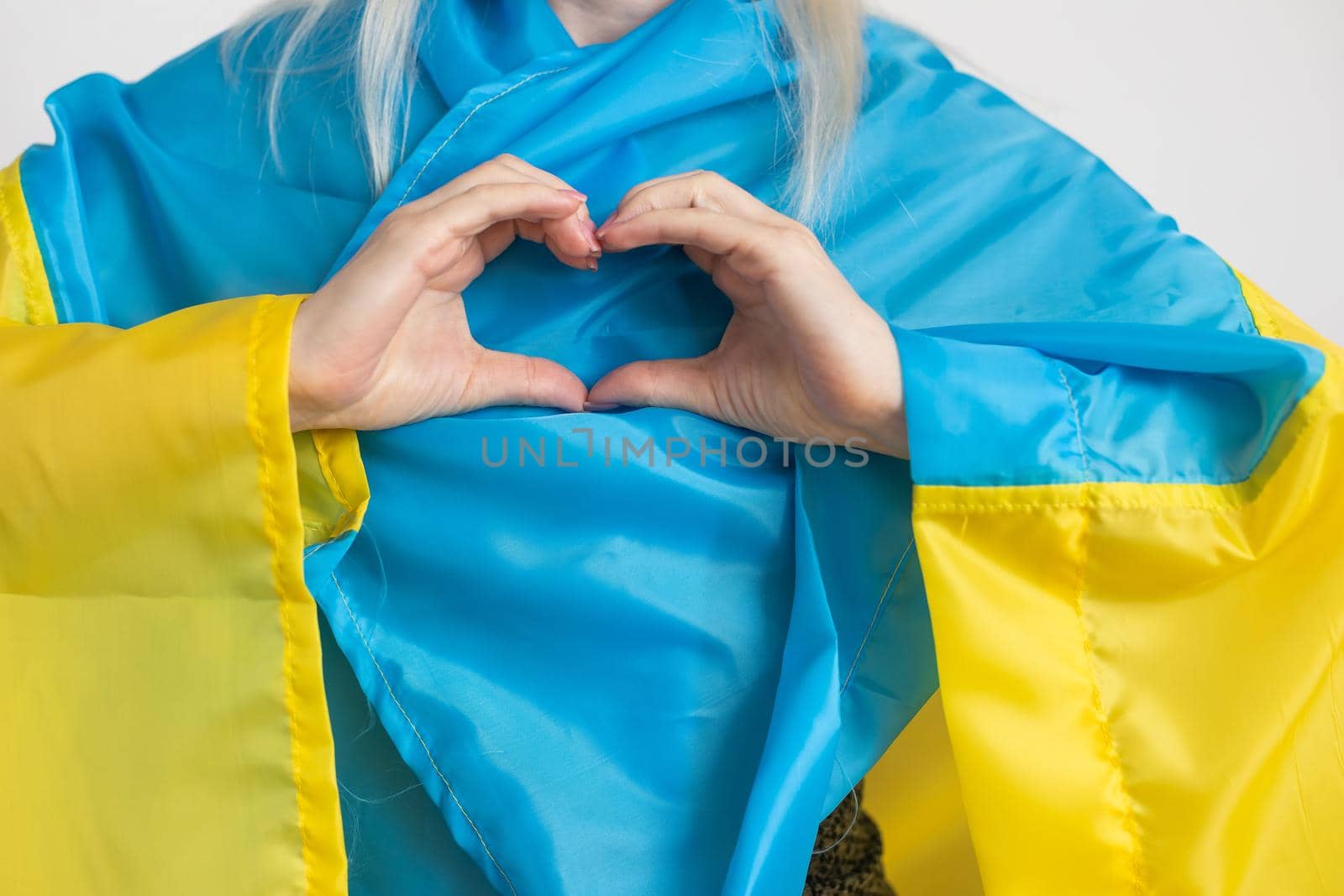 The concept of ending the war in Ukraine. heart in the colors of the flag of Ukraine in female hands. by Andelov13