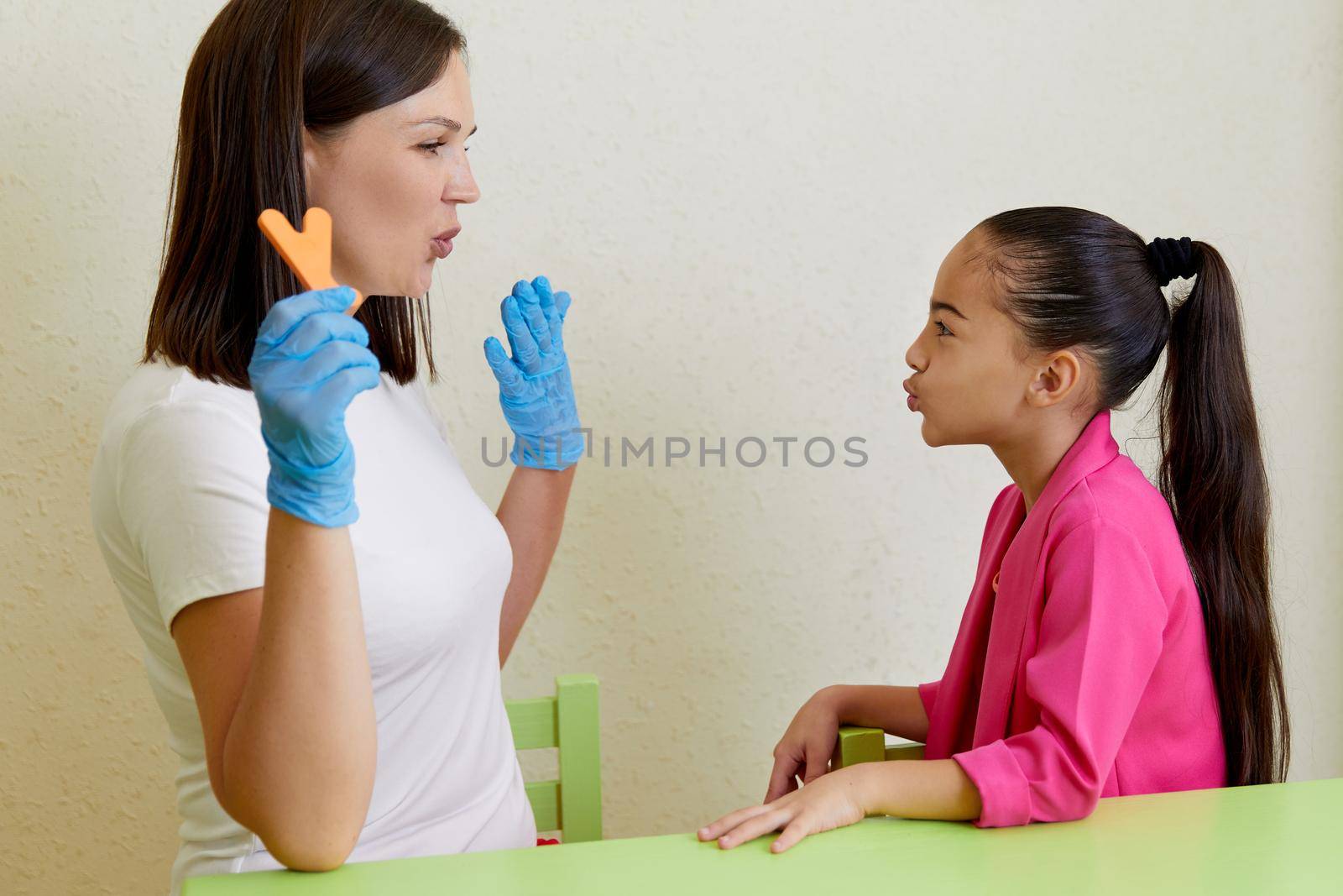 Speech therapist working with girl training pronunciation by Mariakray