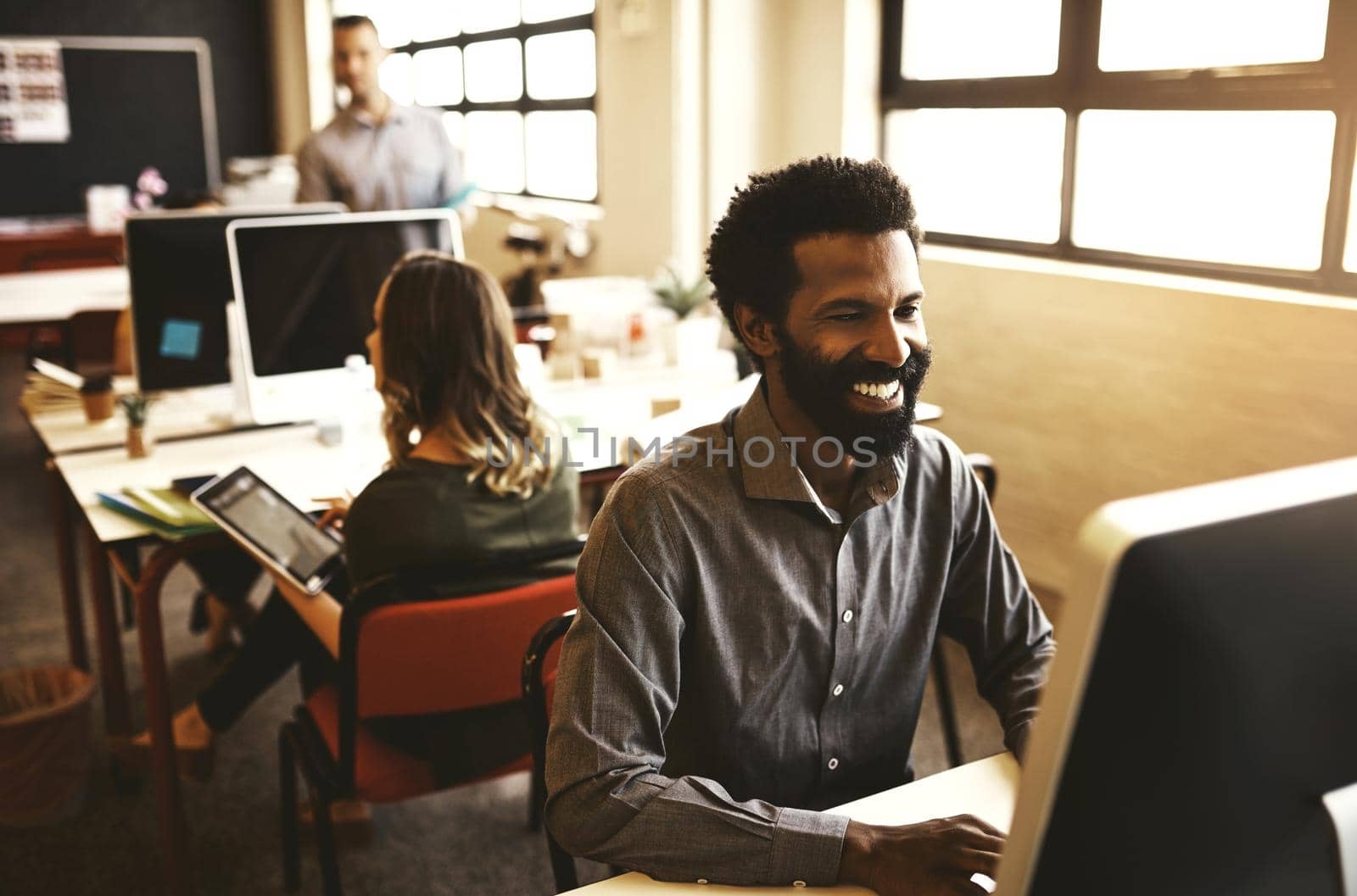 Shot of a handsome businessman sitting at his desk in a modern office.