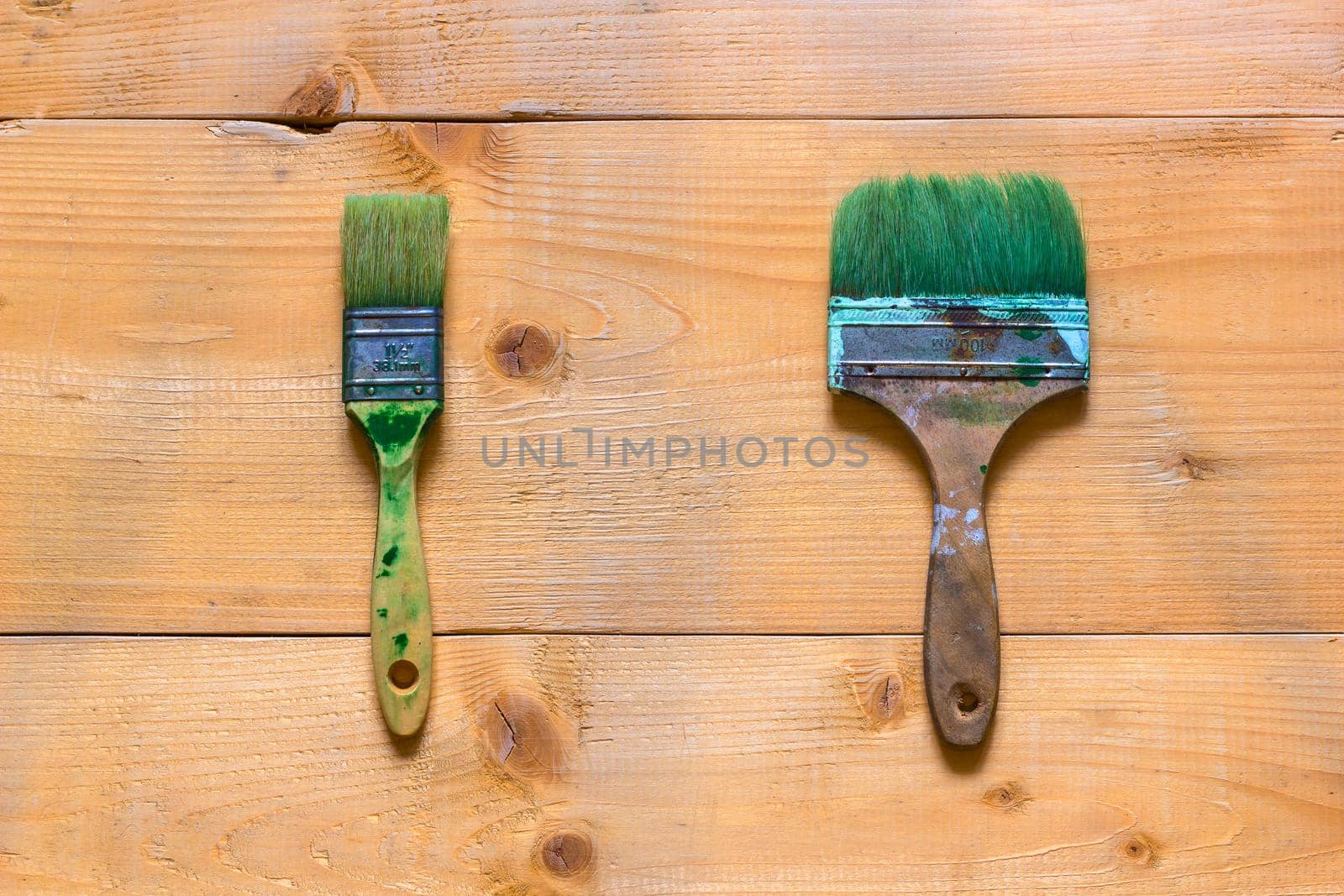 Used brushes on raw wood board surface. Flat view from top.