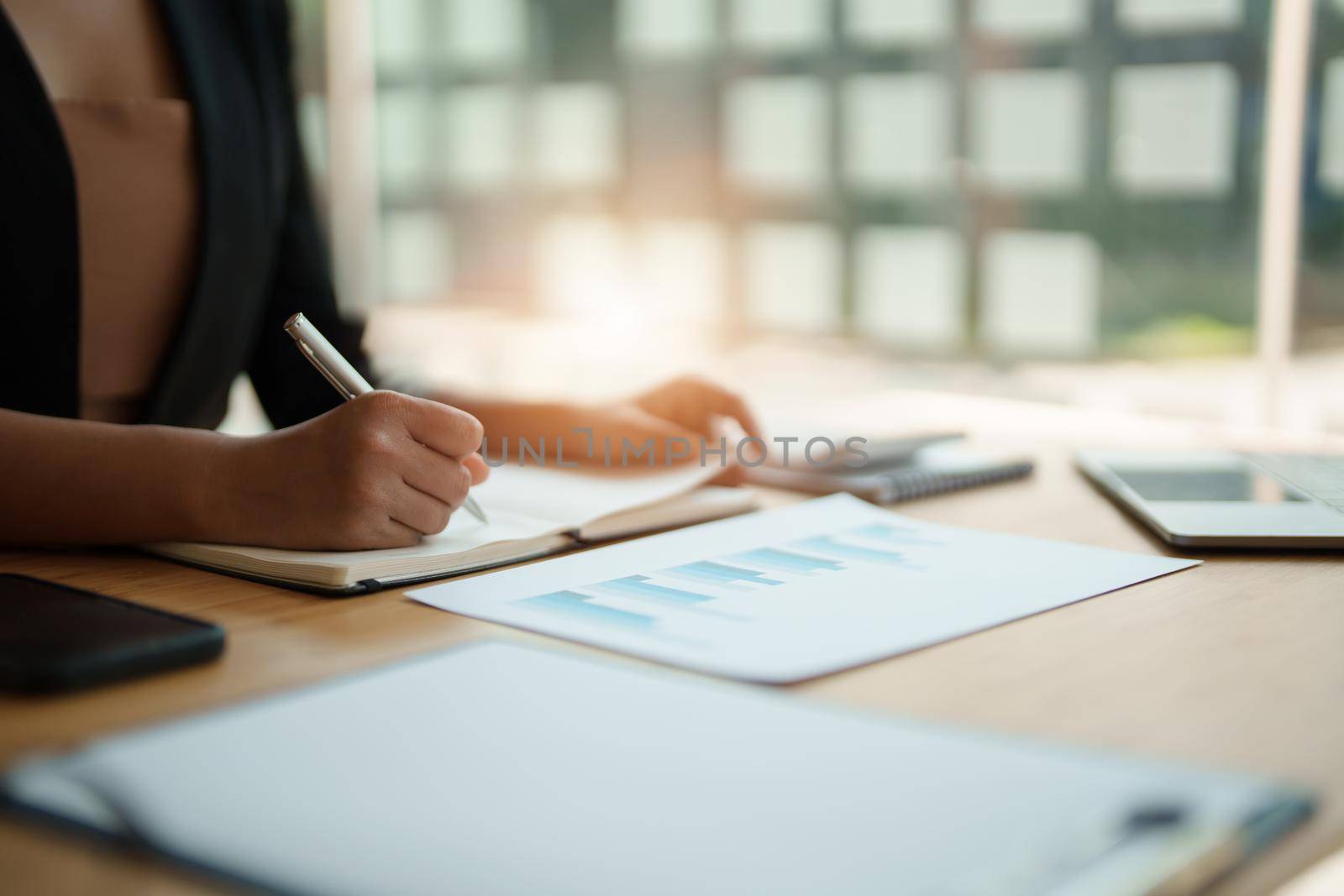 Cropped photo of woman writing making list taking notes in notepad working or learning on laptop indoors- educational course or training, seminar, education online concept.