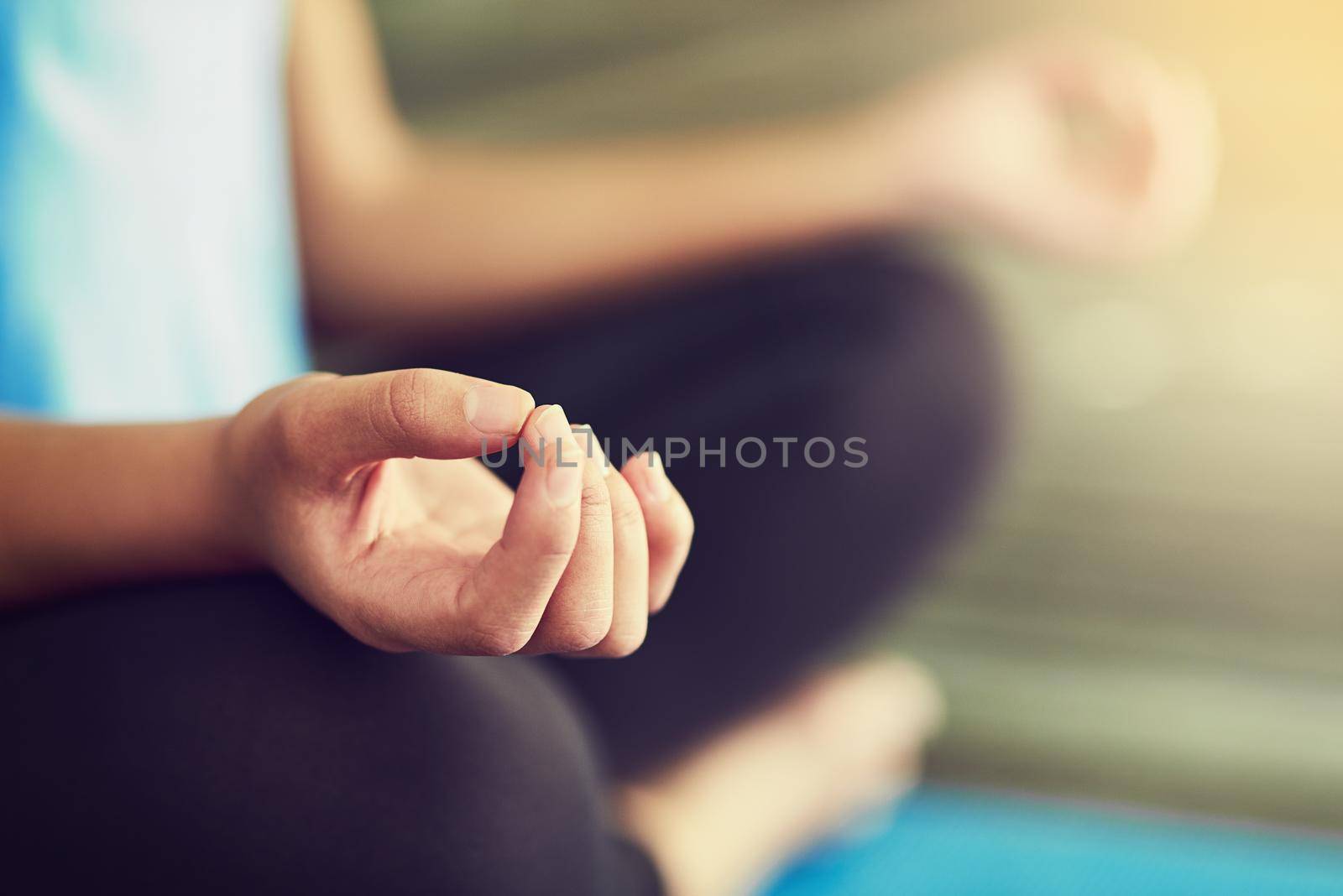 Nothing can disrupt this moment right here. Cropped shot of a young woman sitting in lotus position. by YuriArcurs