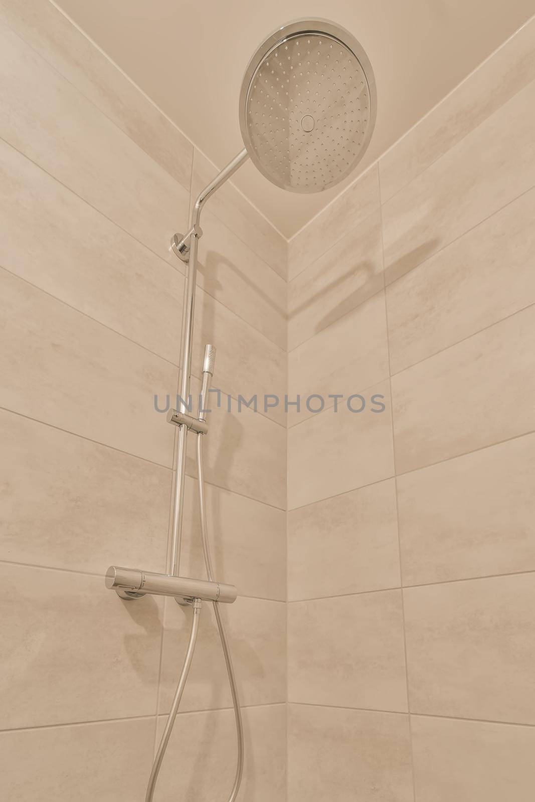 The bathroom is surrounded by marble tiles with shower in the modern house