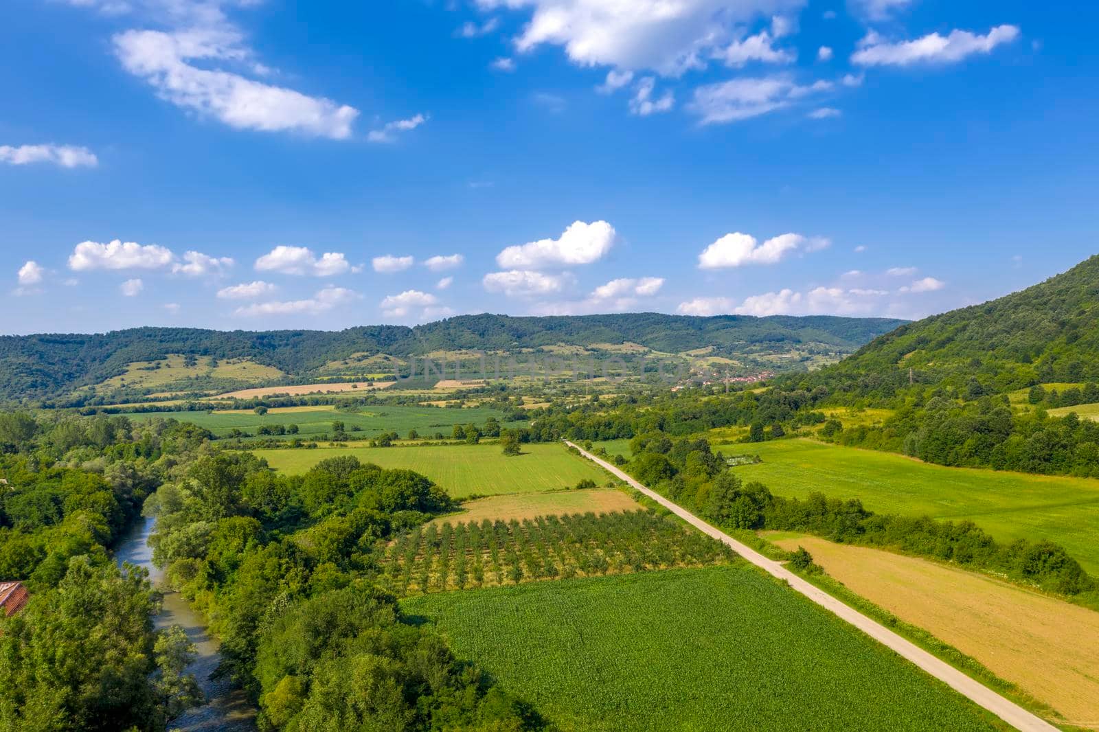 Aerial view from drone of the vast green landscape with river and hills by EdVal