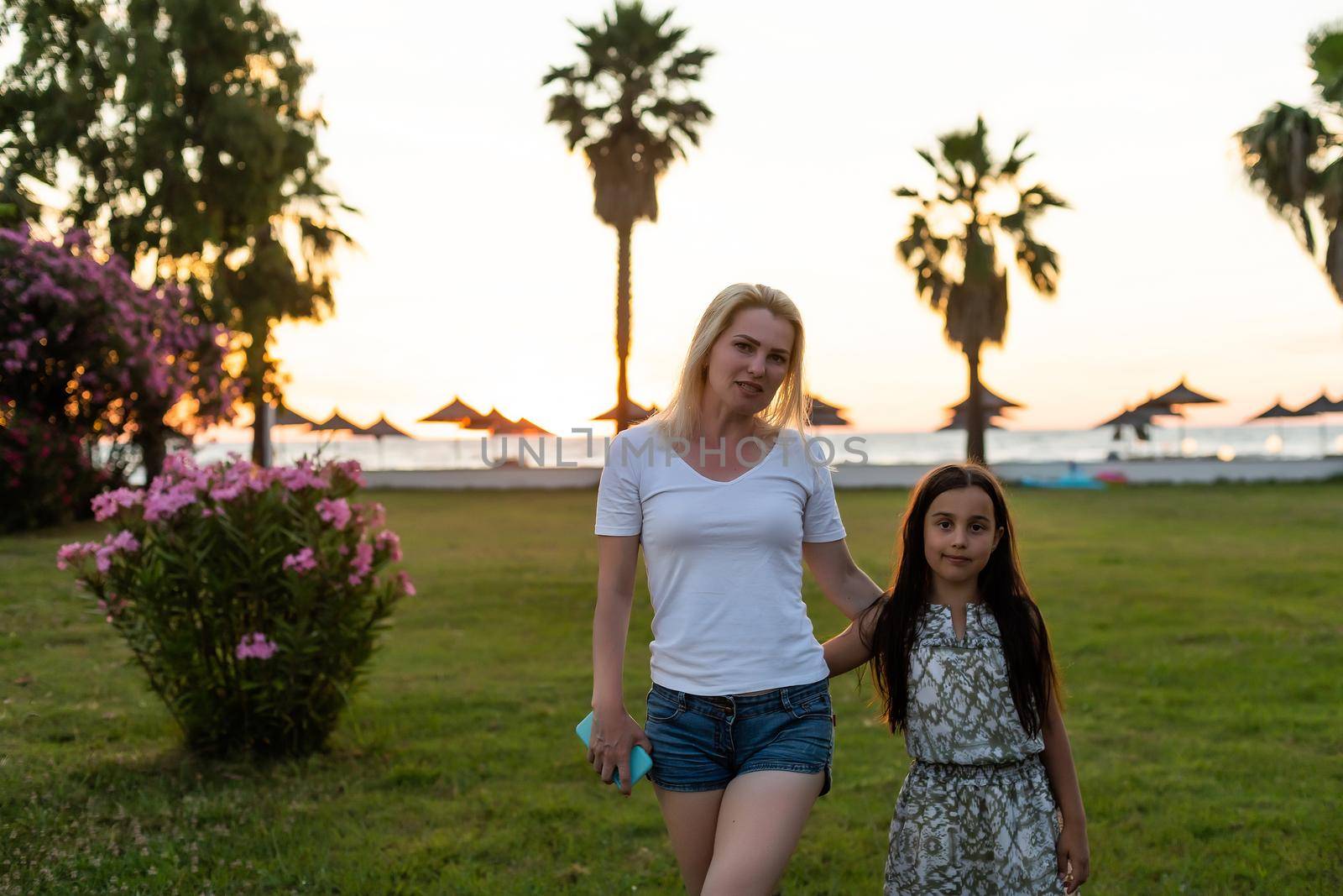 beautiful young mother daughter background summer green grass trees