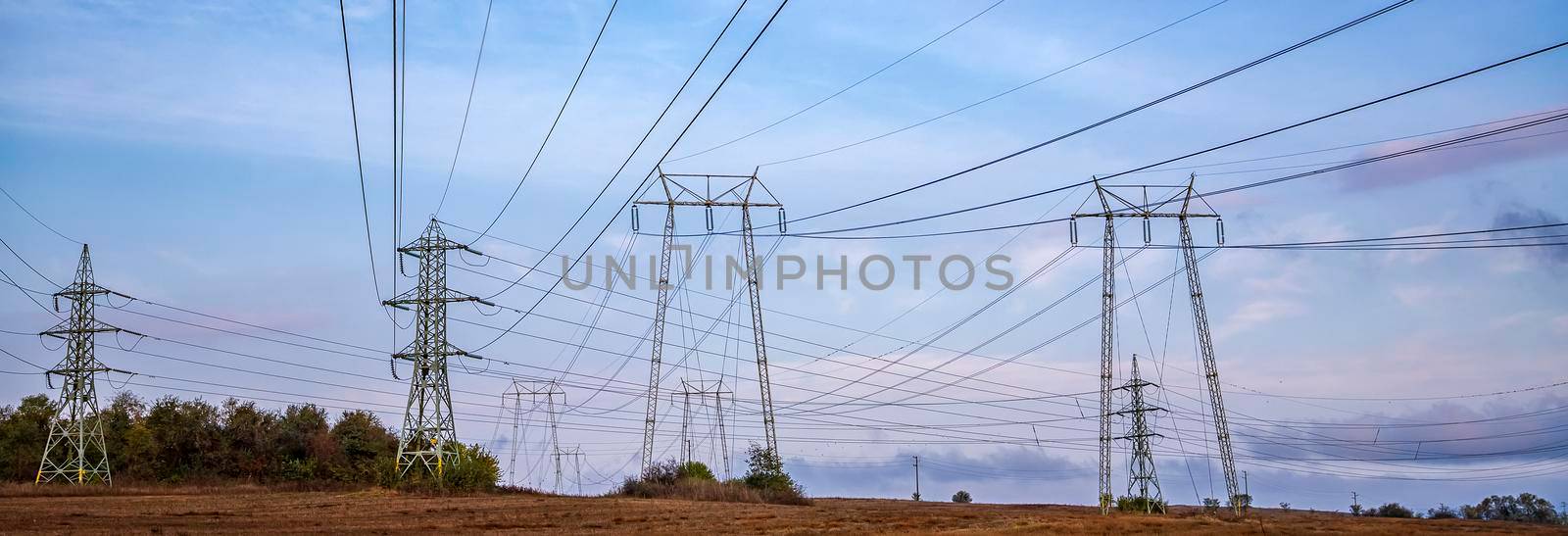 Rows of electrical towers and power lines. Panoramic view by EdVal