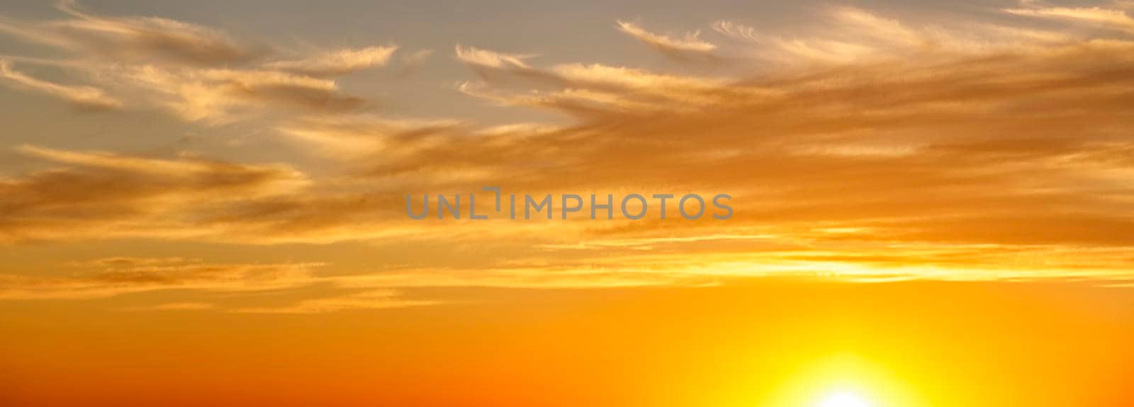 Dramatic colorful clouds with the sun in the sky. Panoramic view