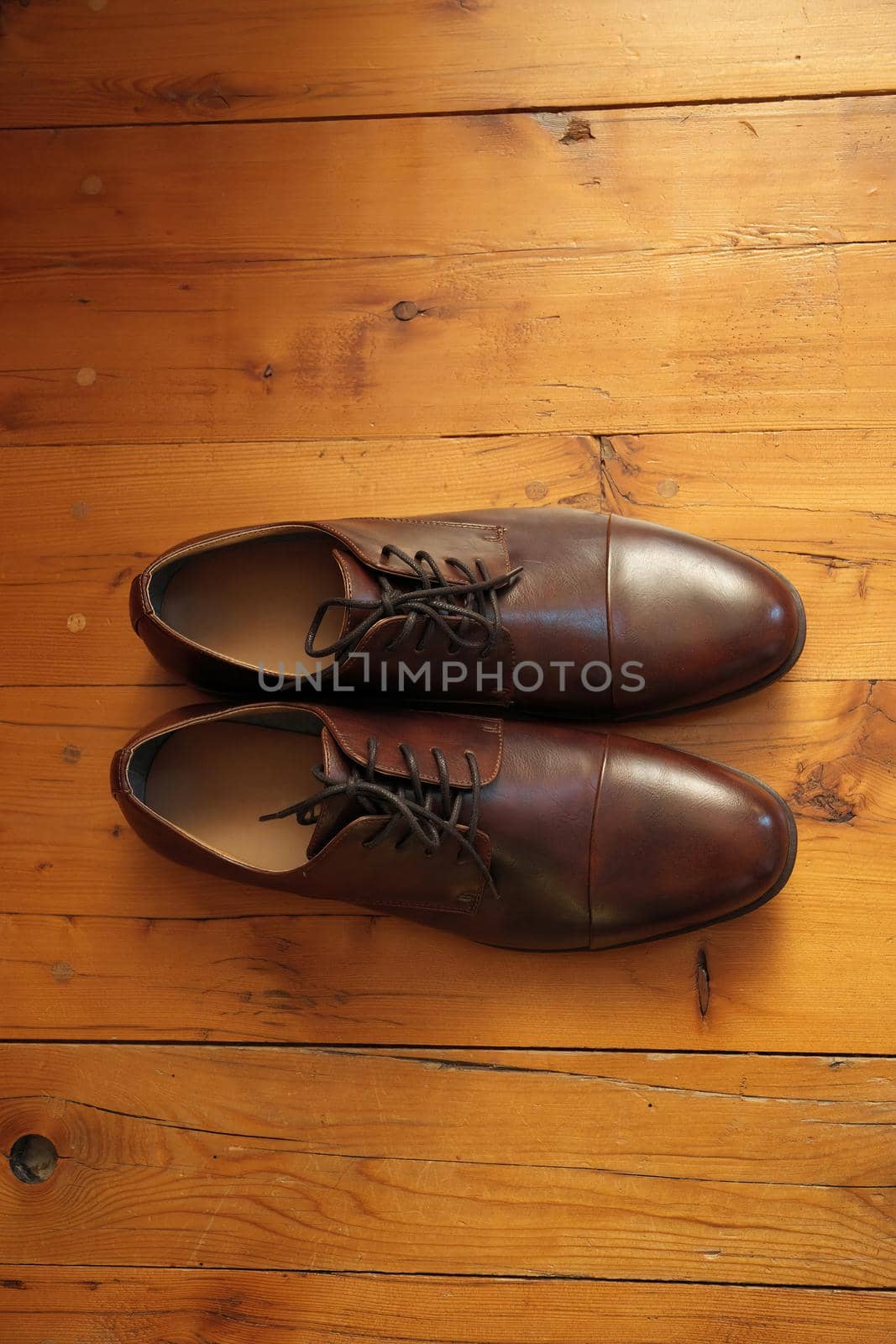 Directly Above Flatlay of Elegant and Classic Brown Derby Leather Dress Shoes on a Rustic Wood Floor with lots of copy space. High quality photo