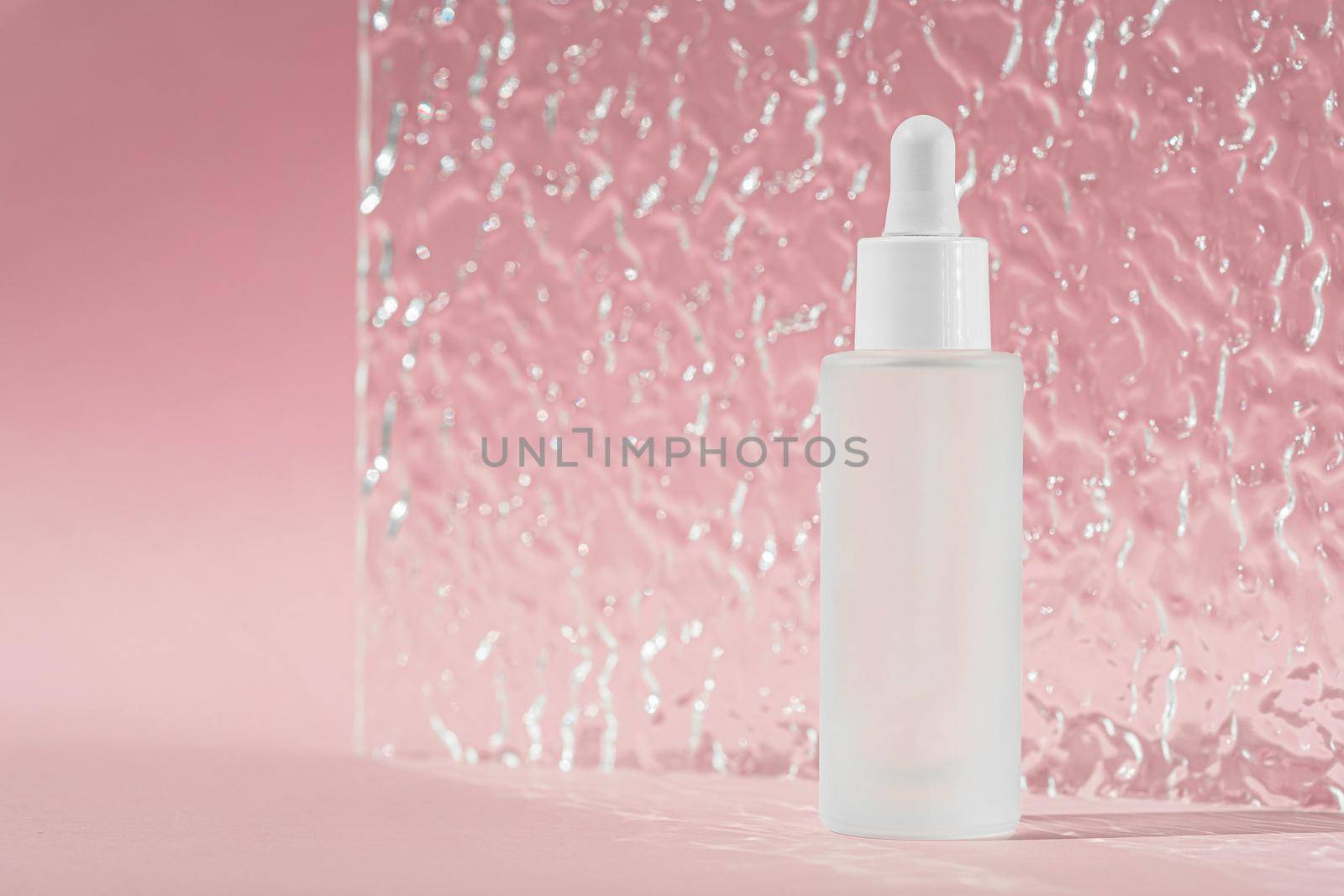 Hyaluronic acid oil mockup. Anti aging serum with collagen and peptides on pink surface with acrylic ribbed plate. Transparent liquid product in glass bottle. by photolime