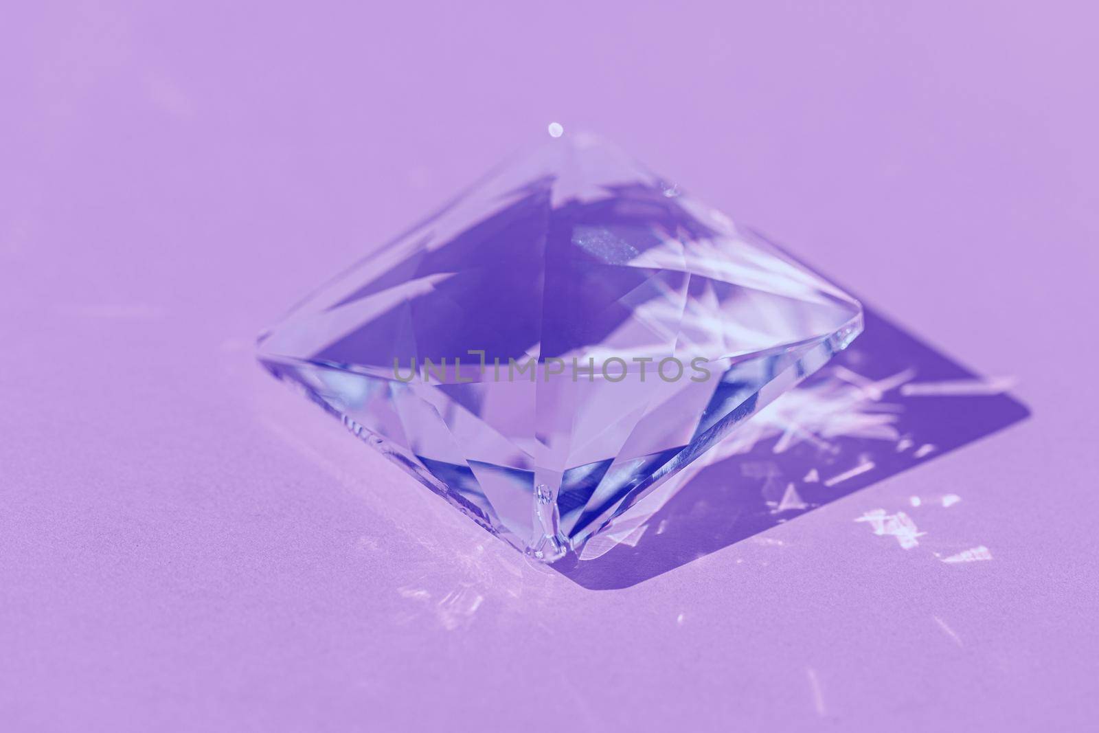 Light spectrum reflected through glass prism. Crystal prism with light diffraction of spectrum colours and reflection with trendy light and hard shadows on lilac background. by photolime